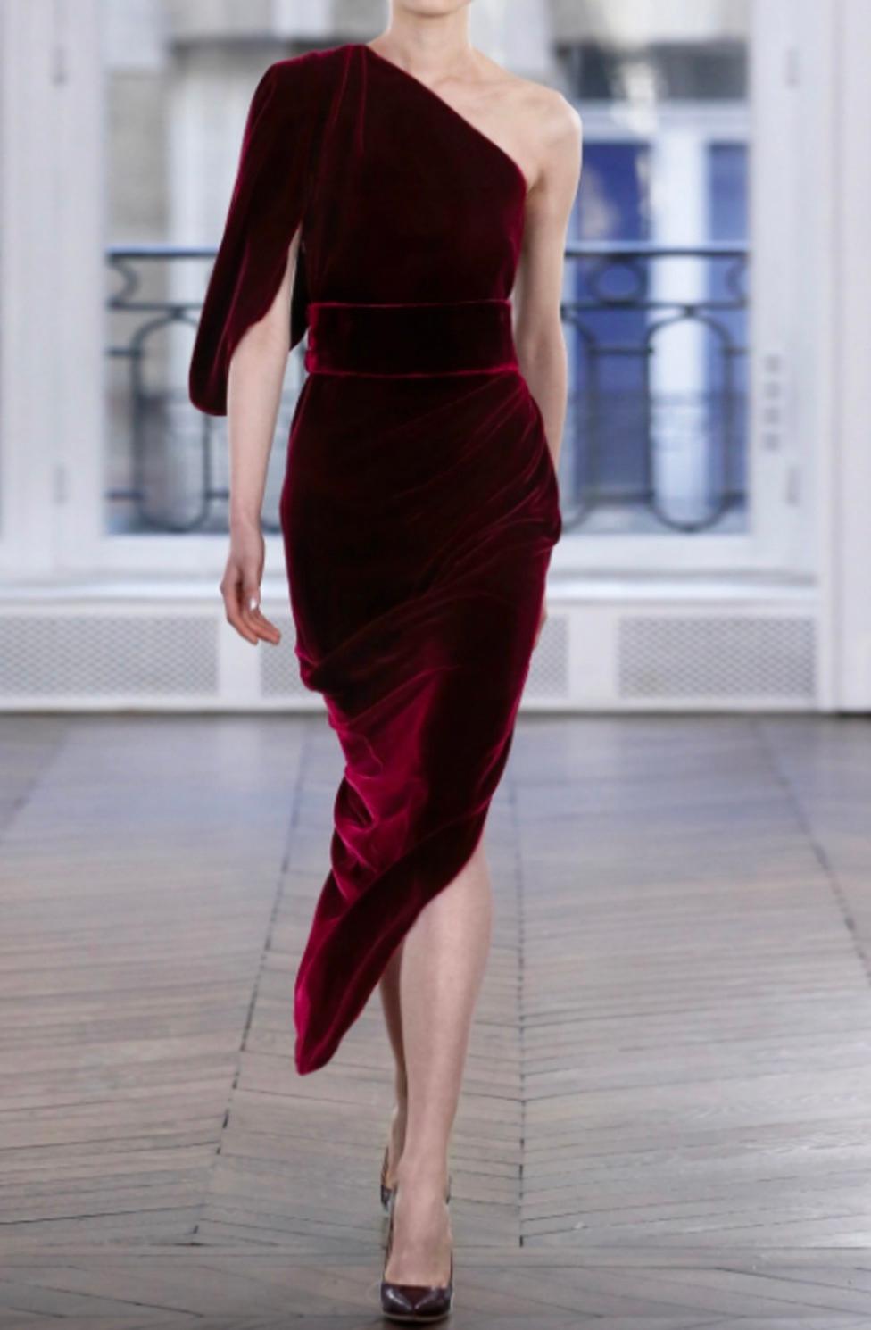 This stunning Ralph & Russo gown from the Fall 2018 collection, famously worn by Lady Gaga, embodies timeless elegance and drama. Crafted from sumptuous burgundy velvet, the Ava gown boasts a one-shoulder design with exquisite draping and an