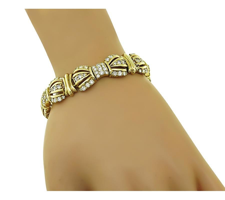 This is an elegant 14k yellow gold bracelet. The bracelet is set with sparkling round cut diamonds that weigh approximately 6.50ct. The color of these diamonds is G-H with VS clarity. The bracelet measures 15mm in width and 7 inches in length. The