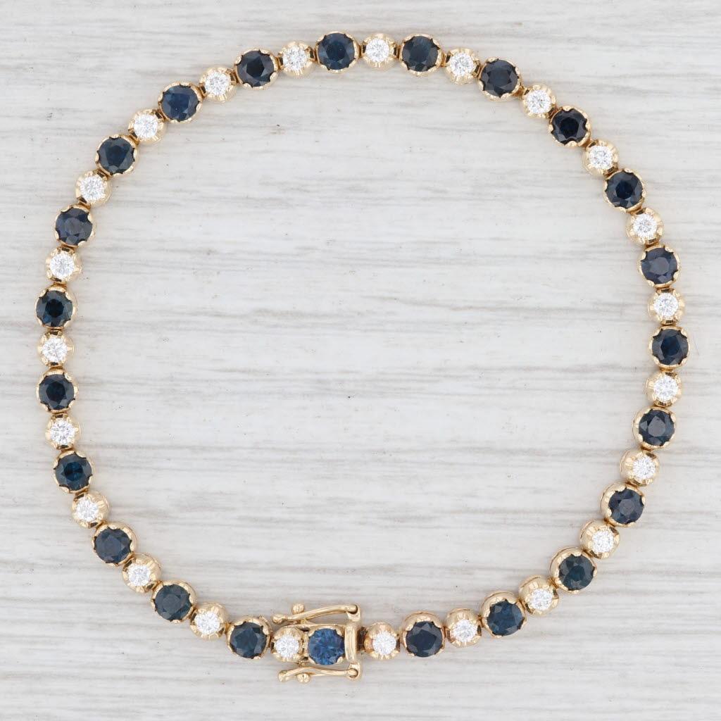 Gem: Natural Sapphires - 5.50 Total Carats, Round Brilliant Cut, Dark Blue Color, Heat Treatment
- Natural Diamonds - 1 Total Carat, Round Brilliant Cut, E - F Color, VS2 Clarity
Metal: 14k Yellow Gold
Weight: 12.9 Grams 
Stamps: 14k
Style: Tennis