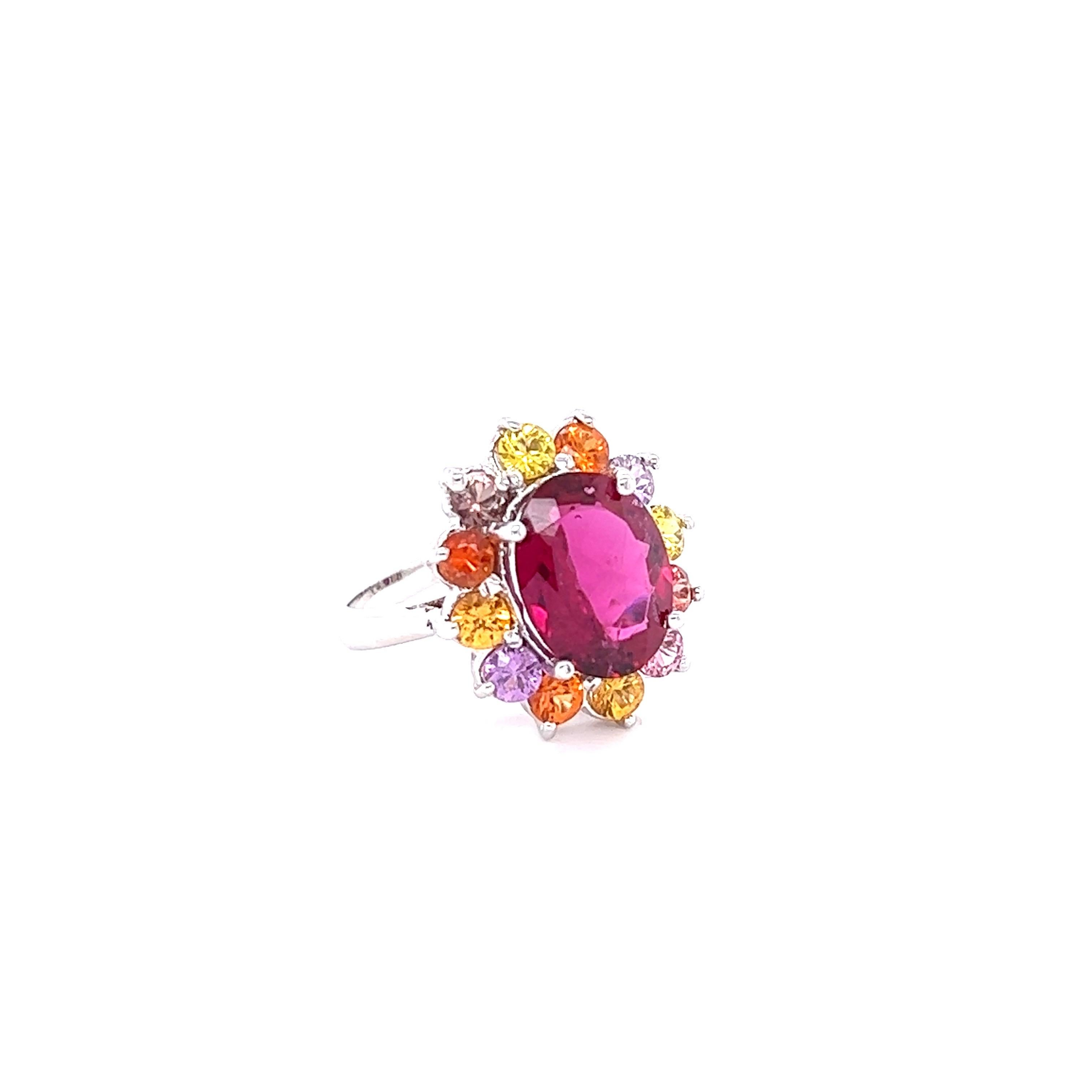 This ring has a 4.23 carat Oval Cut Hot Pink Tourmaline (Rubellite) and is elegantly surrounded by 12 Round Cut Multi-Colored Sapphires that weigh 2.30 carats. The total carat weight of this ring is 6.53 carats.

The tourmaline measures at