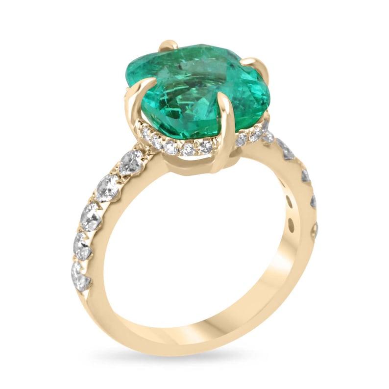 Presenting a bespoke Colombian emerald solitaire with accent diamonds, featuring a captivating cushion-cut Chivor emerald set in 18K yellow gold. This exquisite ring showcases a 5.82-carat emerald, radiating with vivid bluish-green brilliance. The