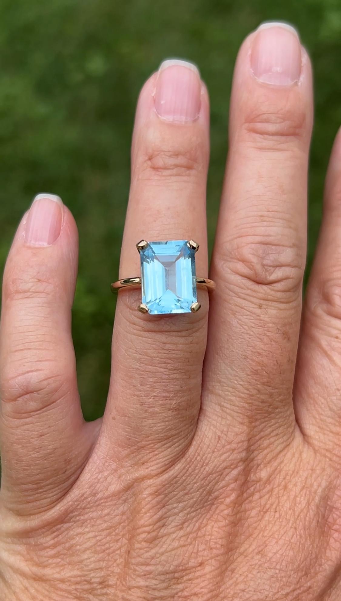 Ein zeitgenössischer Ring aus 14 Karat Gelbgold mit einem auffälligen blauen Topas im Smaragdschliff mit einem Gewicht von etwa 6,55 Karat. Der Topas hat einen lebhaften und leuchtenden himmelblauen Farbton, der durch die sauberen, stufenförmig