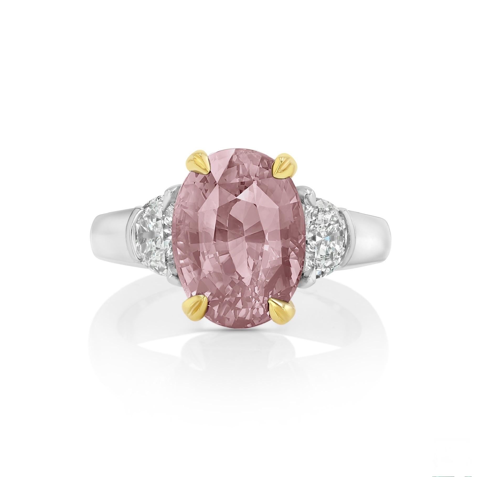 This 6.58-carat, Alexandrite from Tanzania is flanked  by two half-moon cut diamonds totaling 0.57 carats. It is presented in 20K yellow gold basket with an european platinum shank. The enchanting Alexandrite has a strong color change shifting from