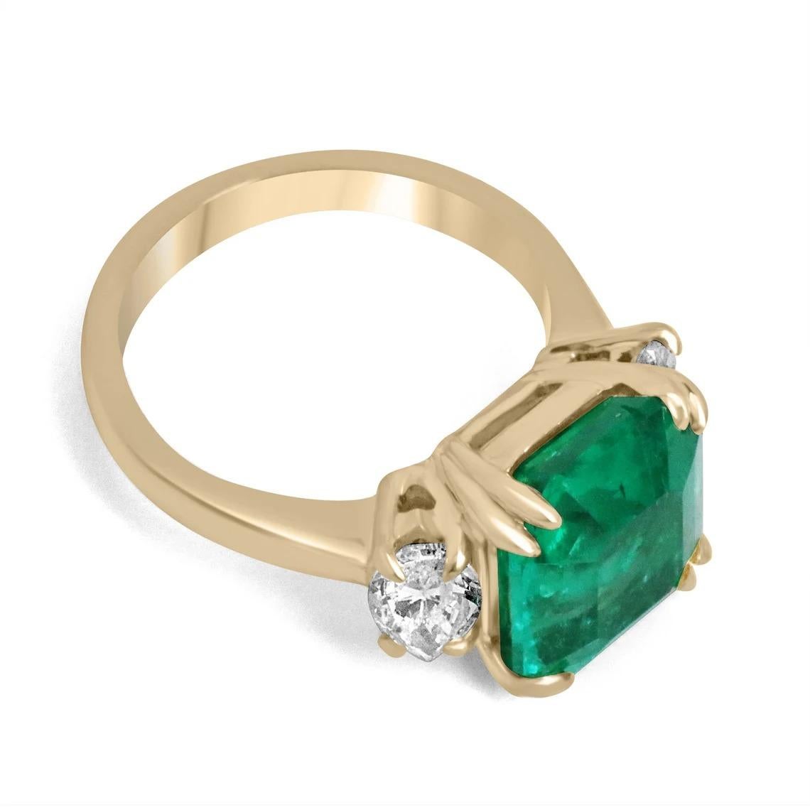 A dramatic emerald and diamond three-stone ring that is sure to turn heads anywhere you may take it. This classic piece features an exceptional 5.49-carat, Colombian emerald that appears much larger due to its widespread. The gemstone displays the