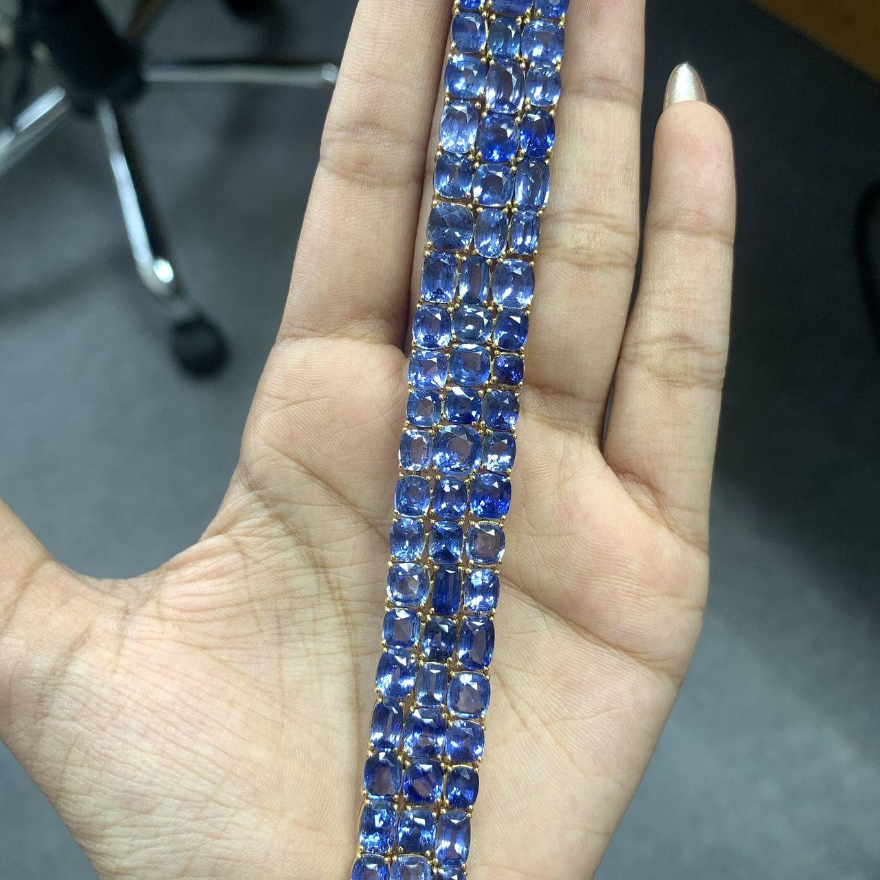 This statement bracelet boasts 66.4 carats of exquisite Ceylon Blue Sapphires, each cushion-shaped and sourced from Sri Lanka. Enhanced through gentle heat treatment, these sapphires gleam with captivating allure. The bracelet itself is a