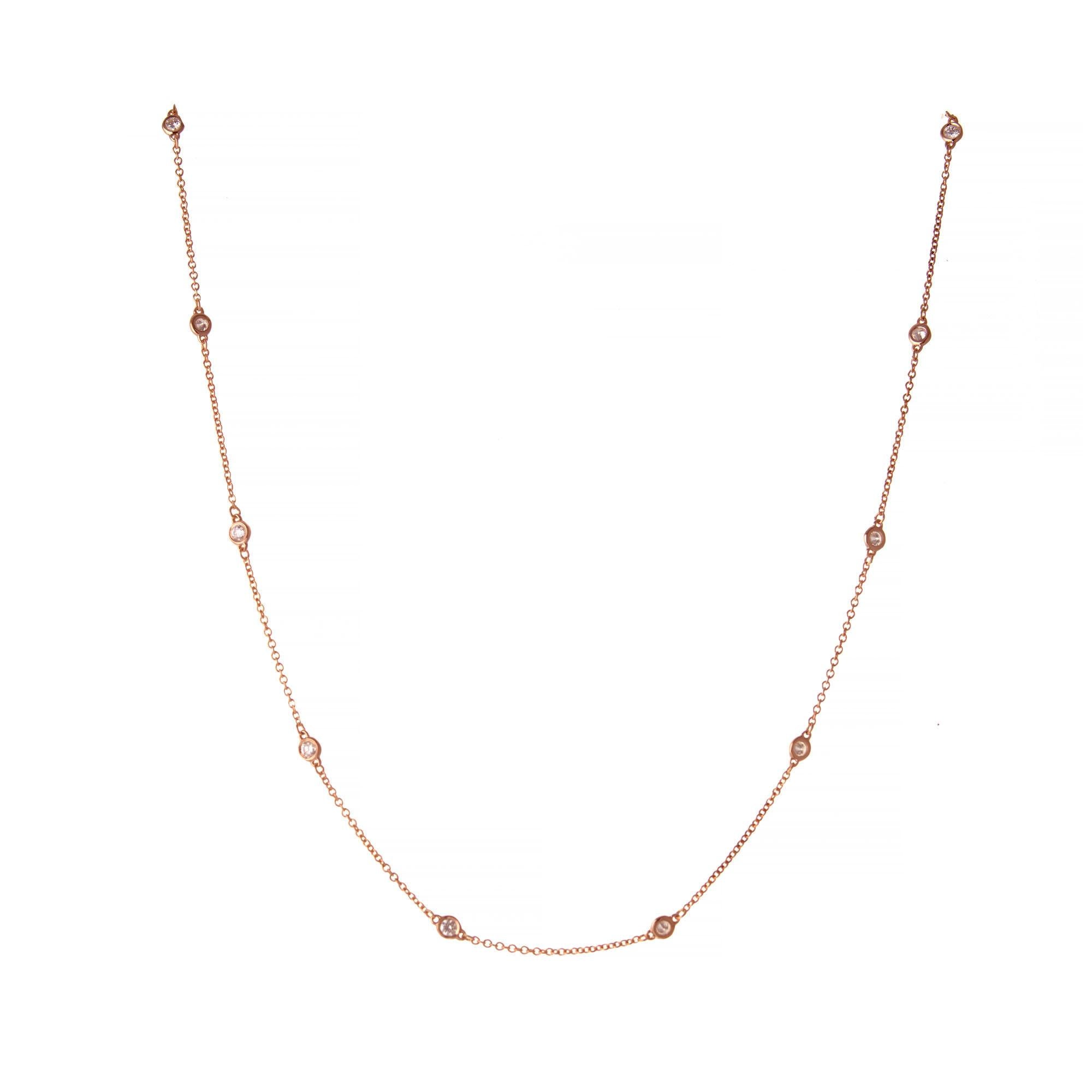 Round brilliant cut bezel set diamond by the yard 14k rose gold necklace.  16 inches.  

12 round brilliant cut diamonds I VS2-SI, approx. .66cts
14k rose gold 
Stamped: 585
2.4 grams
Chain: 16 Inches
