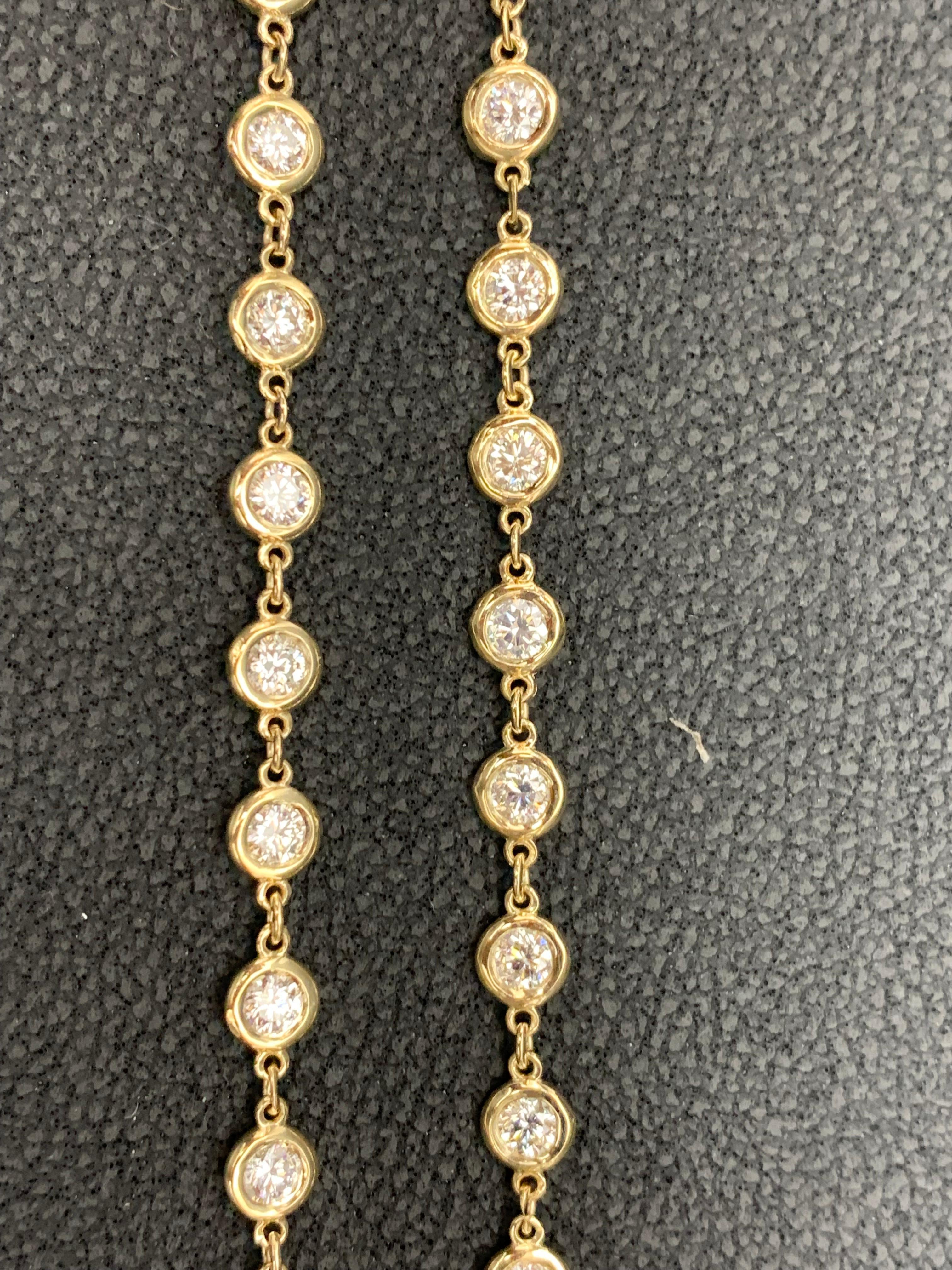 An antique style diamond by the yard necklace showcasing a row of round brilliant diamonds, set in a  bezel design made in 14k yellow gold. Each diamond is spaced evenly on an 24-inch yellow gold chain. 79 Diamonds weigh 6.60 carats total.