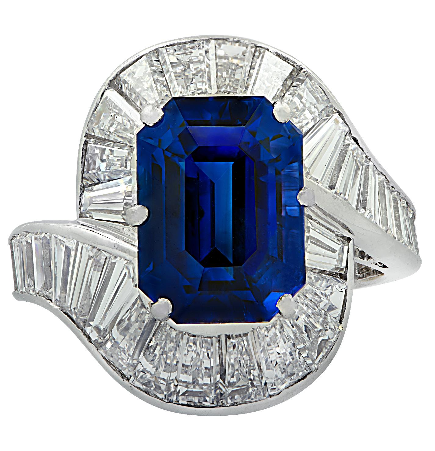 Stunning cocktail ring crafted in platinum, showcasing a gorgeous royal blue emerald cut sapphire weighing approximately 6.60 carats set with 51 baguette cut diamonds weighing approximately 3 carats total, G color, VS clarity, The baguettes swirl