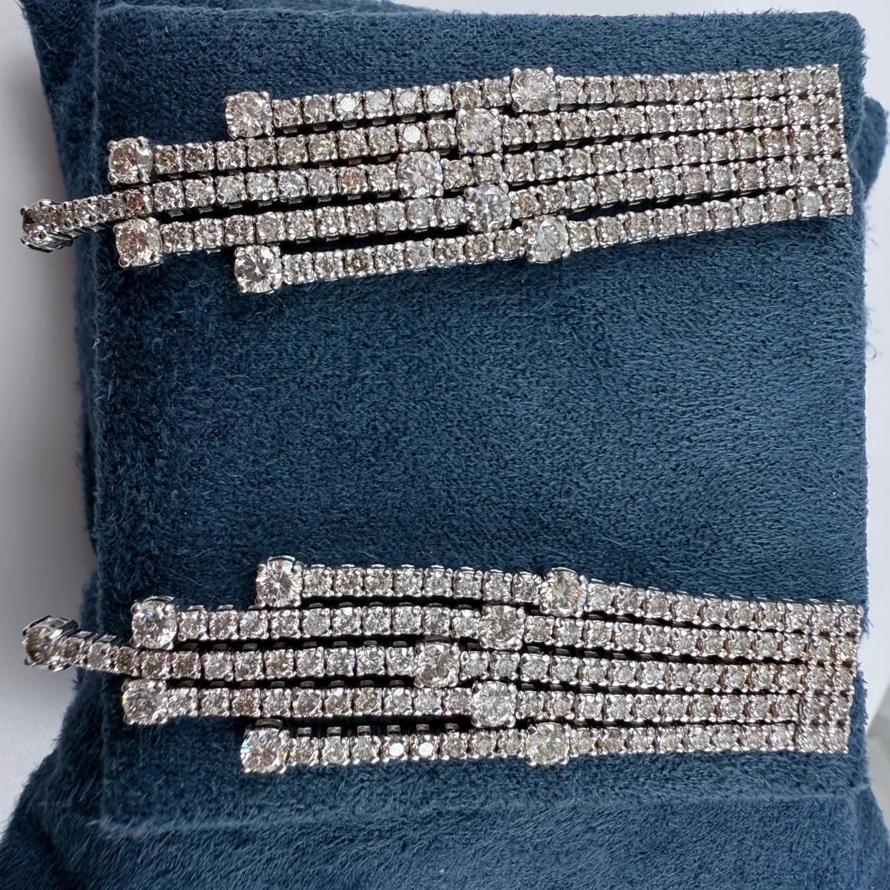 Questi affascinanti orecchini con diamanti a stazione irradiano raffinatezza e brillantezza a ogni movimento. Disegnati con un sorprendente motivo a cascata a cinque file, gli orecchini presentano un totale di 232 diamanti rotondi con taglio a
