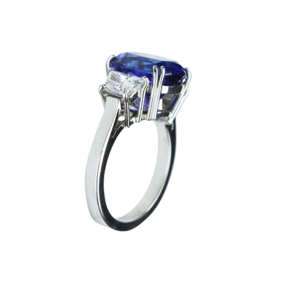 Elegant & finely detailed Solitaire Engagement  Ring, center set with a securely nestled 6.60 Carat Cushion-cut Vivid Blue Violet Tanzanite, clarity: internally flawless (IF); dimensions: 11.3mm x 9.8mm, set either side by Brilliant full cut
