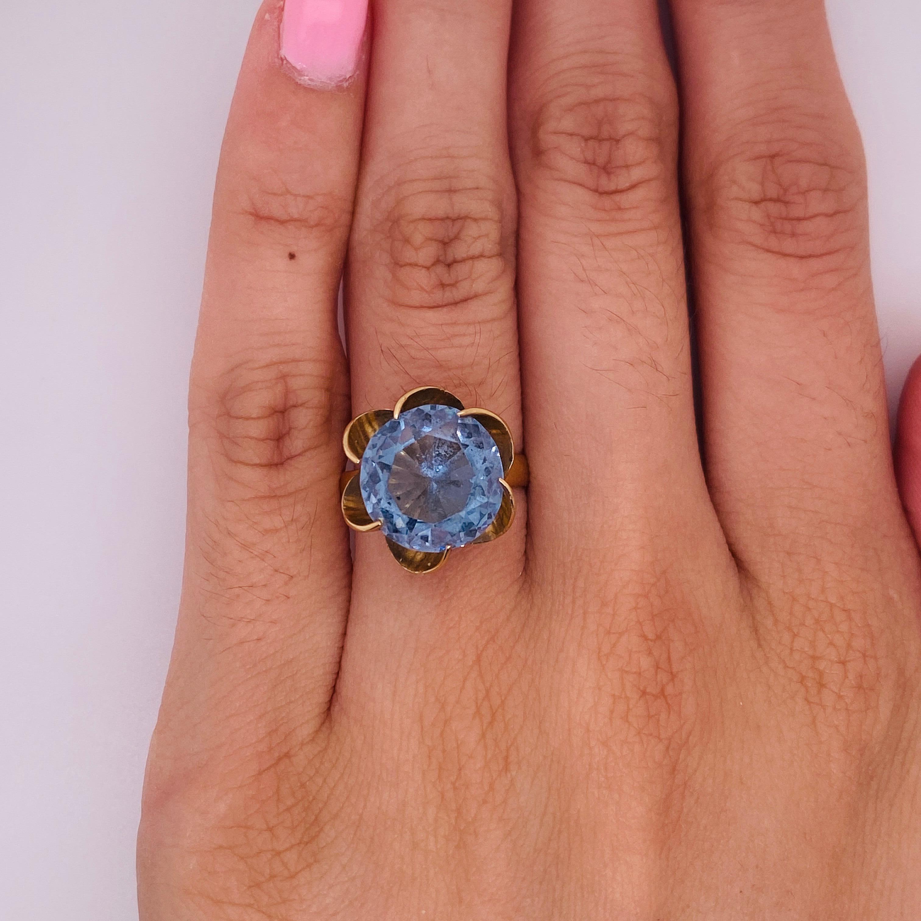Adorn a magnificent finger with this gorgeous 6.60 carat Swiss blue topaz wrapped in the sweeping petals of a stylish flower. Blue topaz is one of the December birthstones. Honor a special someone that was born in December (graduation, anniversary,