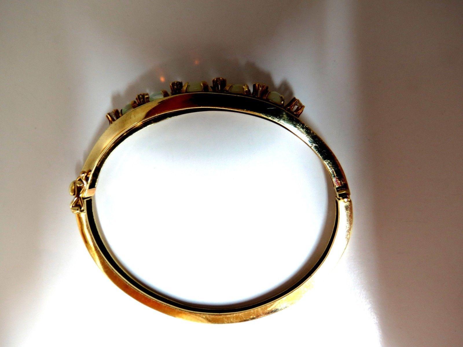 Bracciale Bangle con Opali Australiani Naturali e Diamanti  

6,00ct Opali

Opale centrale: 6 x 8 mm

 Tagli cabochon eccellenti e colori vivaci.

Diamanti da 0,60 carati:

Round e tagli completi 

 Colore G, purezza Vs2.

14kt. Oro giallo 

18,8