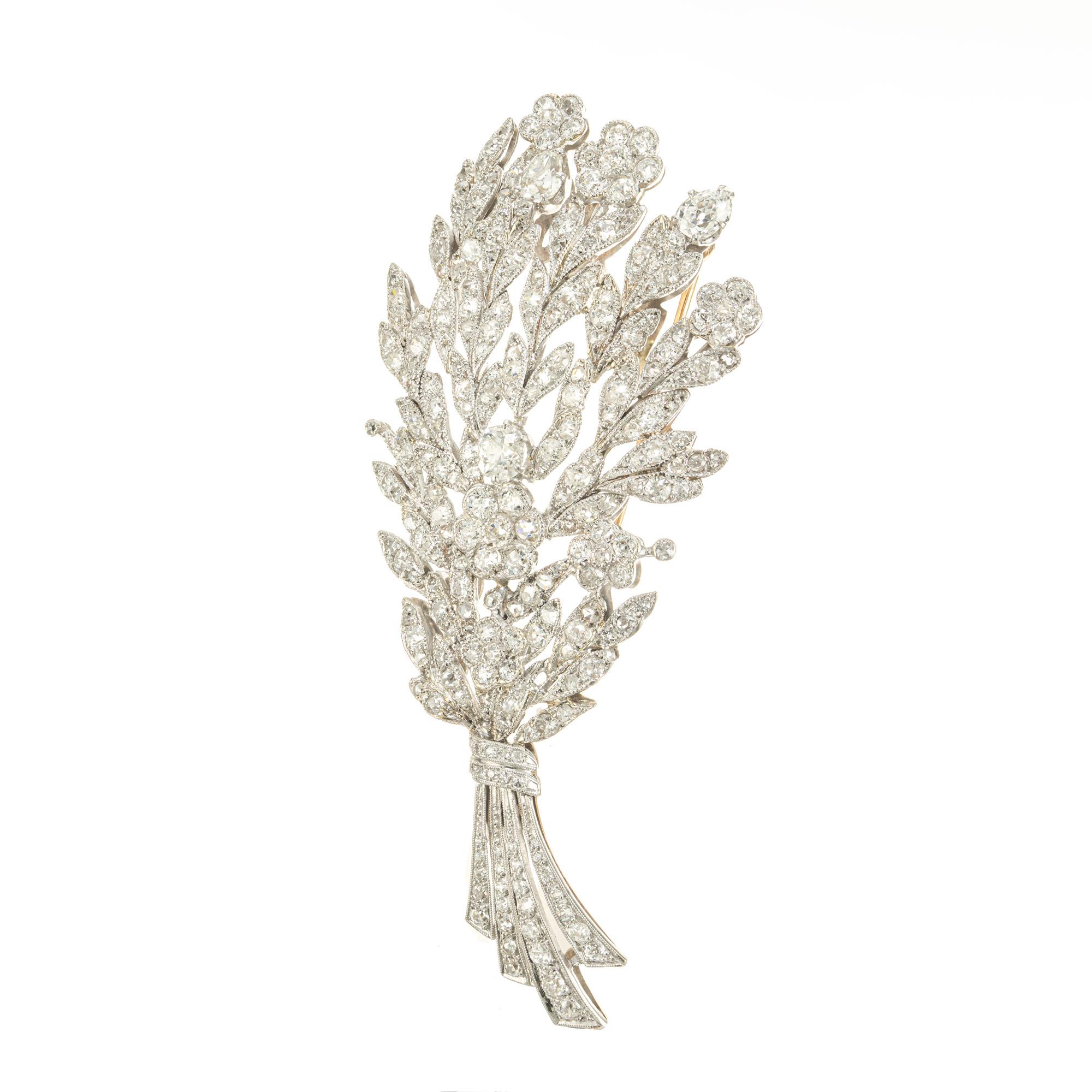 Circa 1910 wonderful diamond flower brooch. 1 round .42ct center diamond with 2 pear shaped diamonds totaling .90cts accented with 212 round diamonds, 5.30cts in a platinum flower design with 14k rose gold back frame and stem pin.  Intricate bead