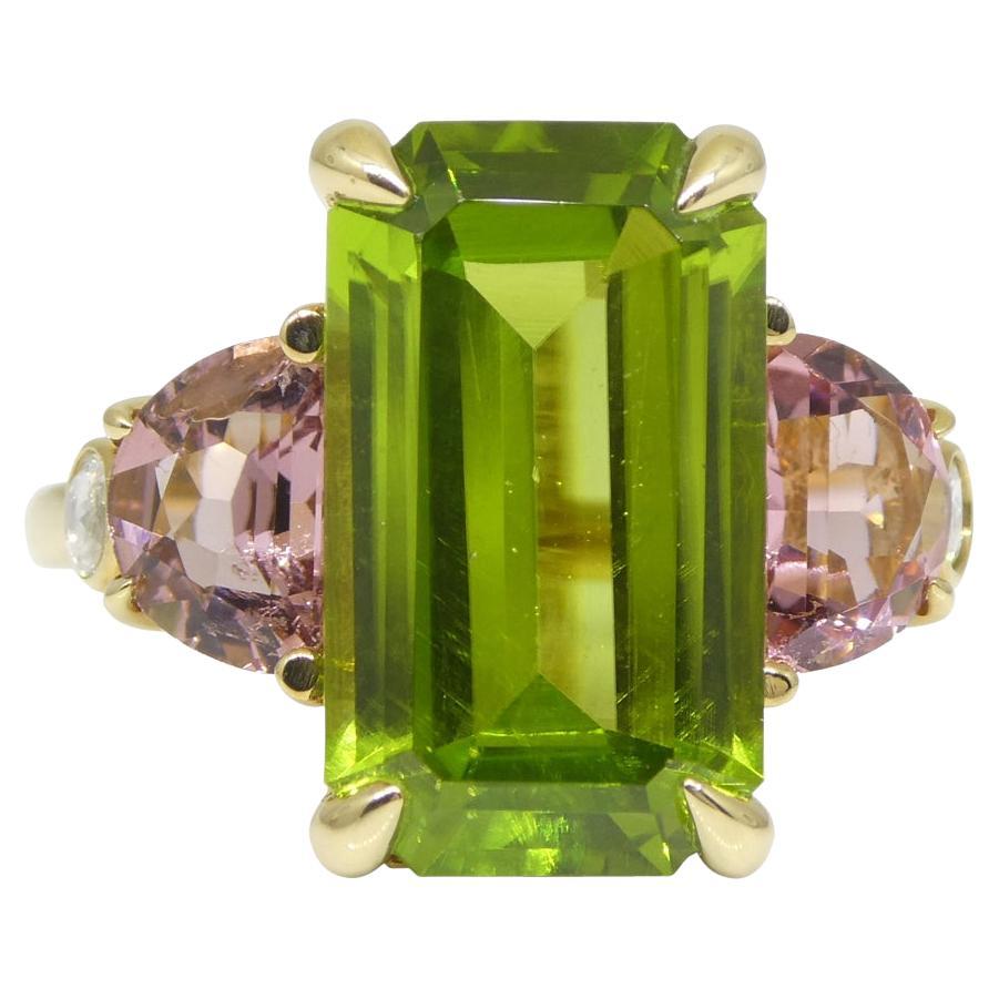 This is a stunning Peridot Ring is set with a pair of pink tourmaline and diamonds in an 14k yellow gold setting. 

Gem Type: Peridot
Number of Stones: 1
Weight: 6.62 cts
Measurements: 15.21 x 8.74 x 5.35 mm
Shape: Emerald Cut
Cutting Style Crown: