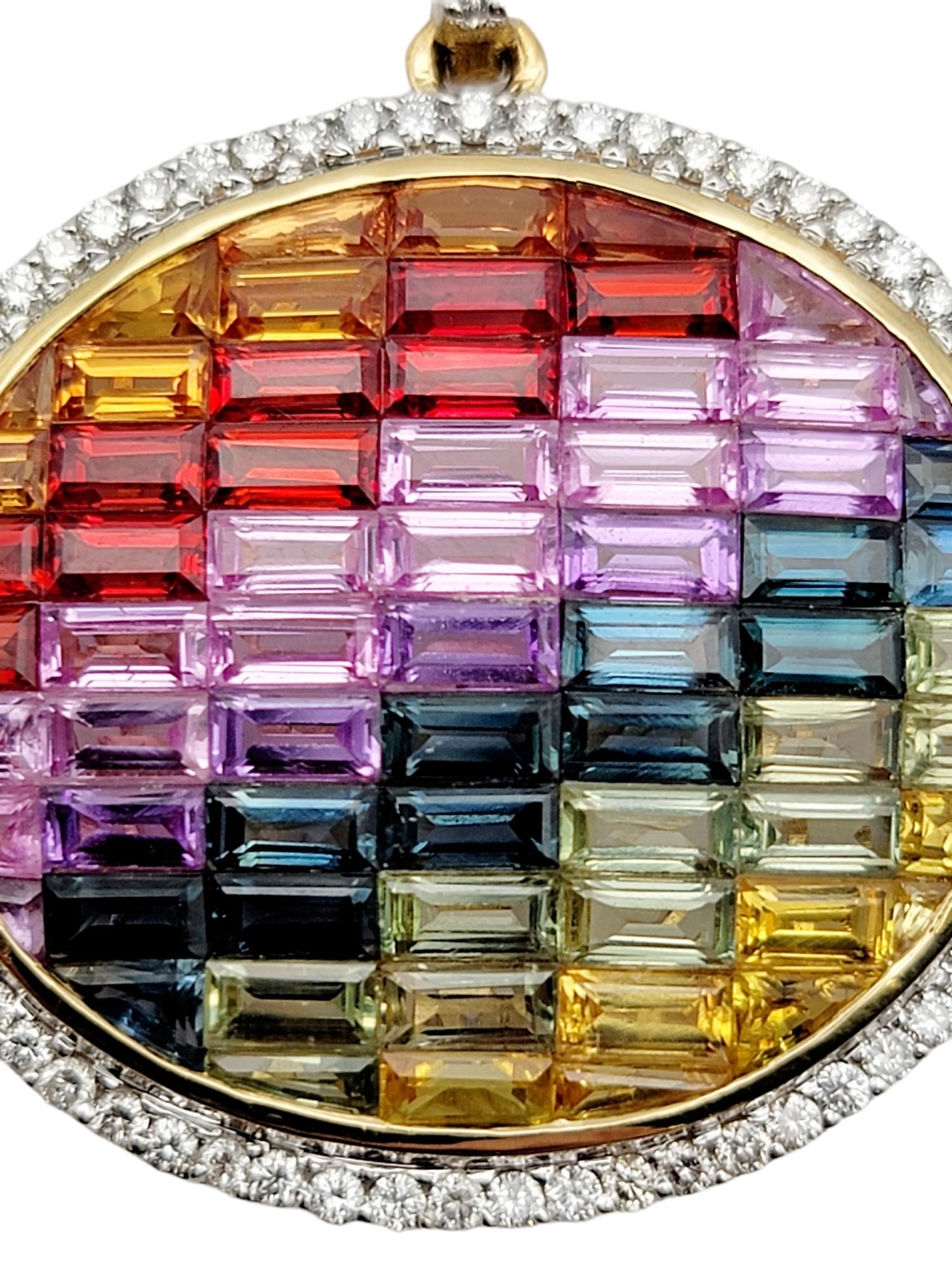 Vibrant and unique 'rainbow' sapphire pendant with a dazzling diamond halo. Colorful oval pendant is filled with invisible set baguette shaped lab-created sapphires in hues of red, orange, yellow, green, blue and purple. The natural diamond halo is