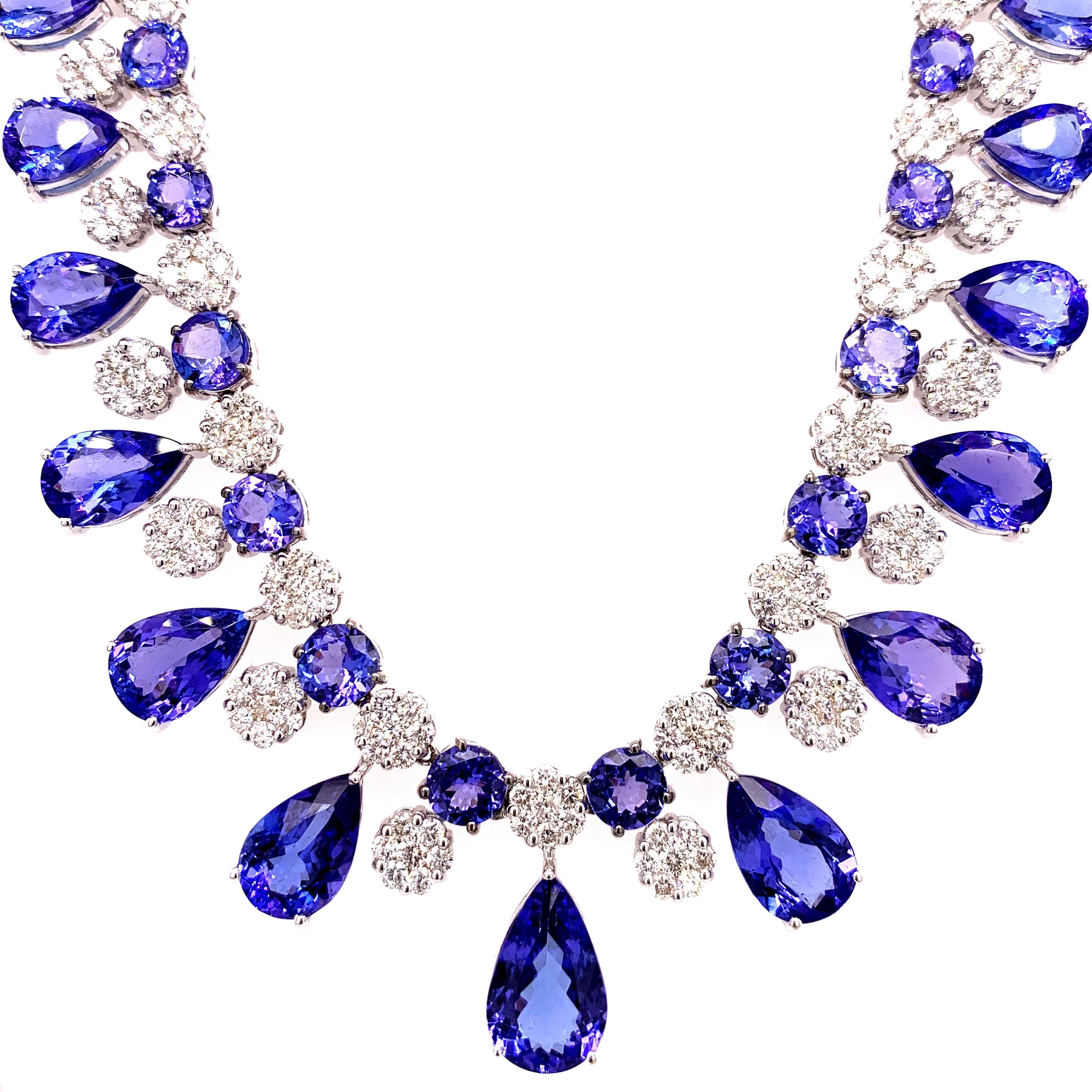 Majestic tanzanite diamond necklace earrings set. High lustre, transparent clean, violet-bluish, purple, pear, round faceted, 66.36 carats natural tanzanites mounted in an open basket with bead prongs, accented with a cluster of round brilliant cut