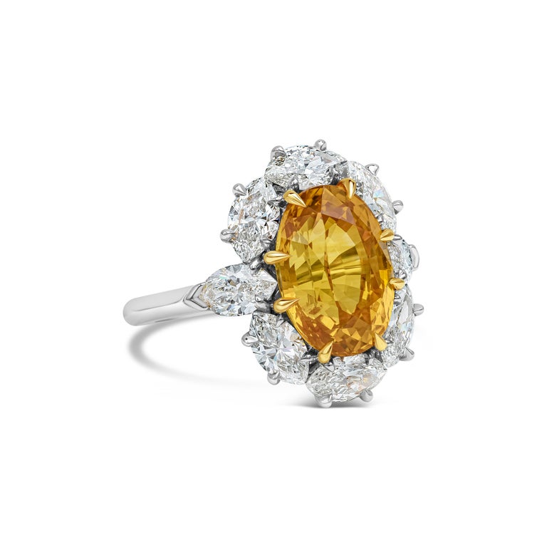 Showcasing a color-rich oval cut orange sapphire weighing 6.64 carats, surrounded by a single row of brilliant marquise cut diamonds set in a flower design halo. Diamonds weigh 2.42 carats total. Made 18k gold and platinum. GIA certified Orange