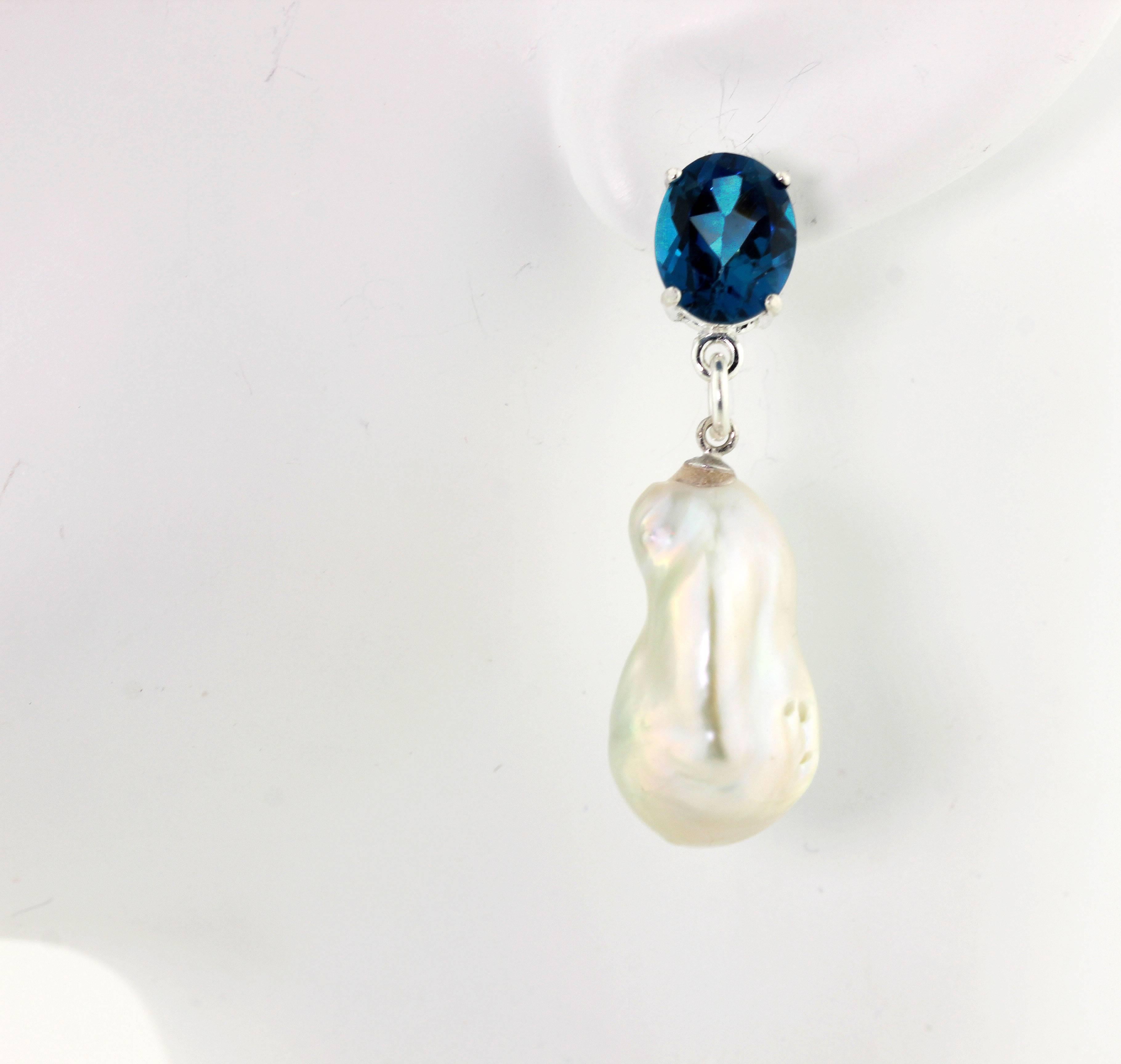 Gorgeous brilliant blue oval Topaz (10 mm x 8 mm) dangle beautiful silvery white cultured baroque Pearls on sterling silver stud earrings.  They hang approximately 1.5 inches long.
