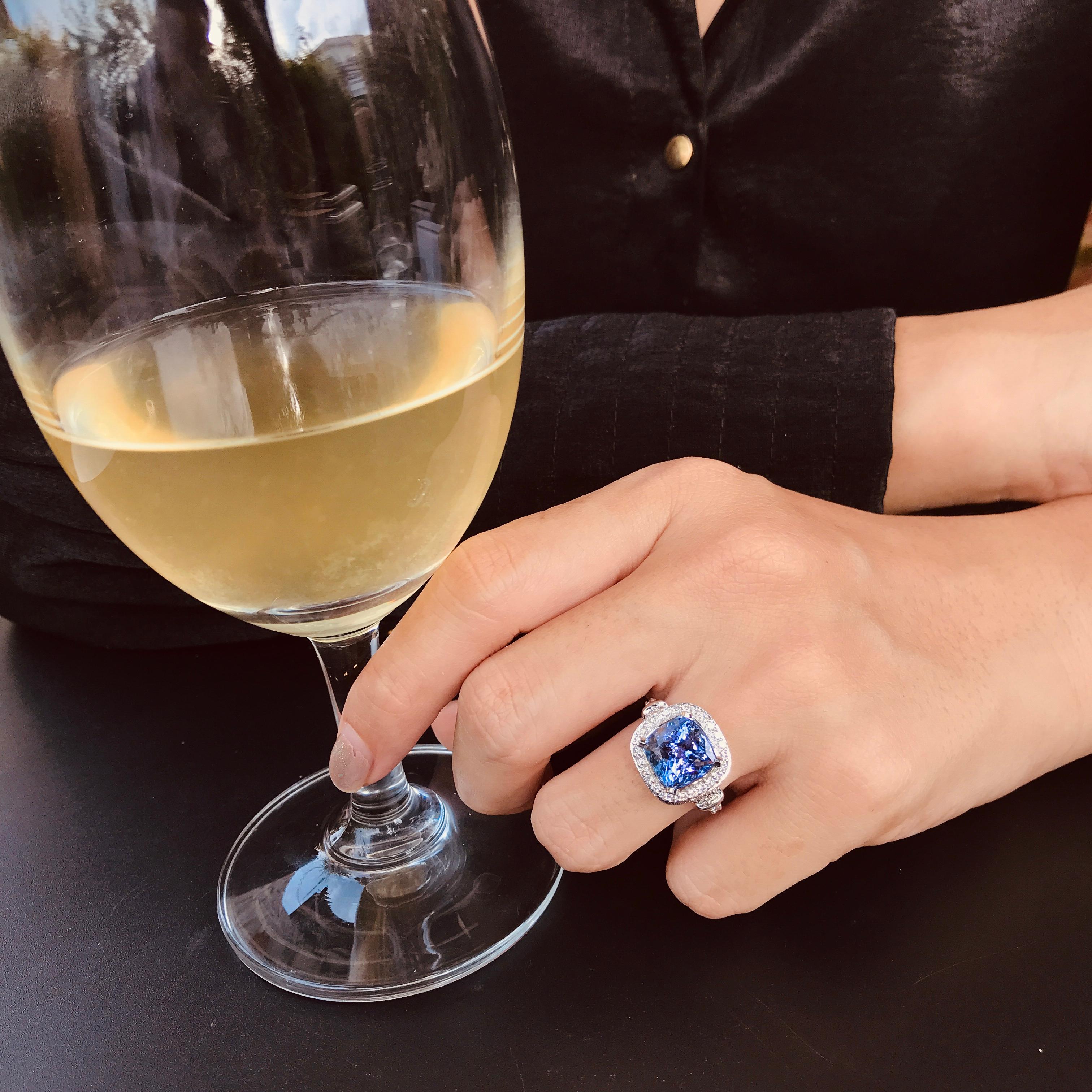 This stylish ring features a 6.68 carat blue-violet tanzanite surrounded by a halo of colorless round cut diamonds. Additional diamonds line the triple split shank and under the gallery completing the shimmering elegance of this ring.

Ring