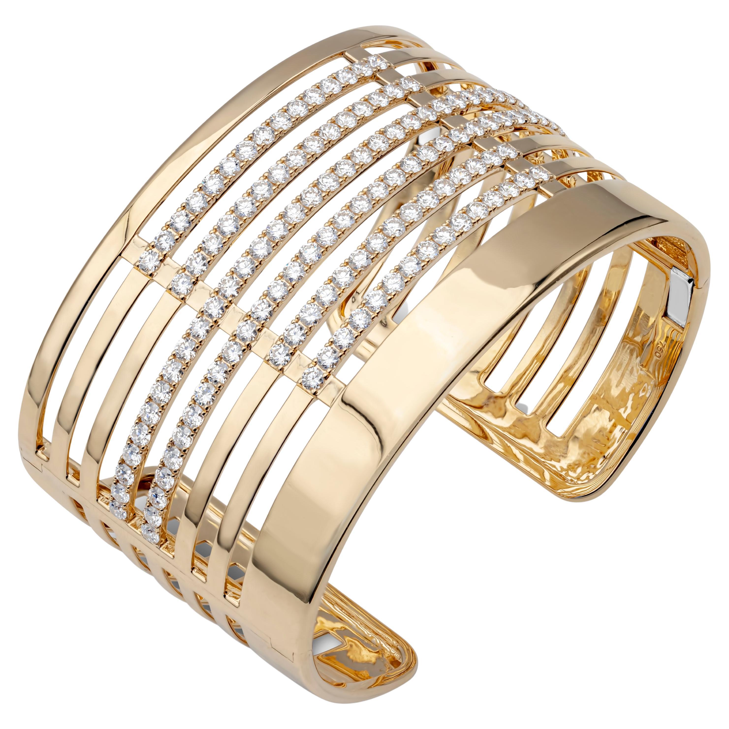 Showcasing a stylish and stunning 18k yellow gold bangle bracelet accented with 130 brilliant round diamond weighing 6.69 carats total, F-G color and VS-SI in clarity, set in a timeless open-work large cuff design. 6.5 inches in length and 40mm
