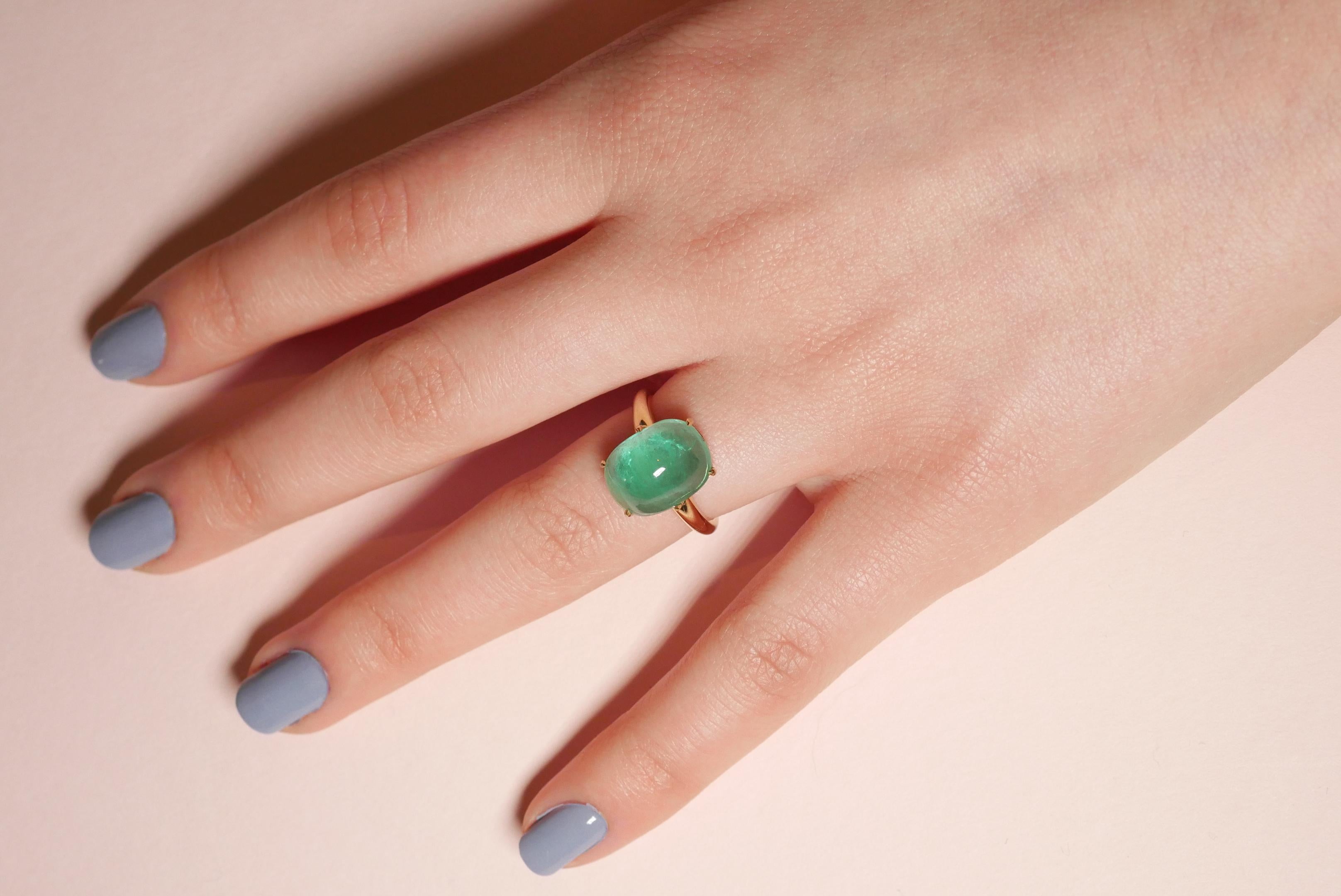 One of a kind dazzling 6.7 carat emerald cabochon ring in 18k yellow gold, with open back setting and talon-shaped claws complemented by a minimal and elegant smooth band. This contemporary handcrafted beauty is versatile and easy to wear on its own