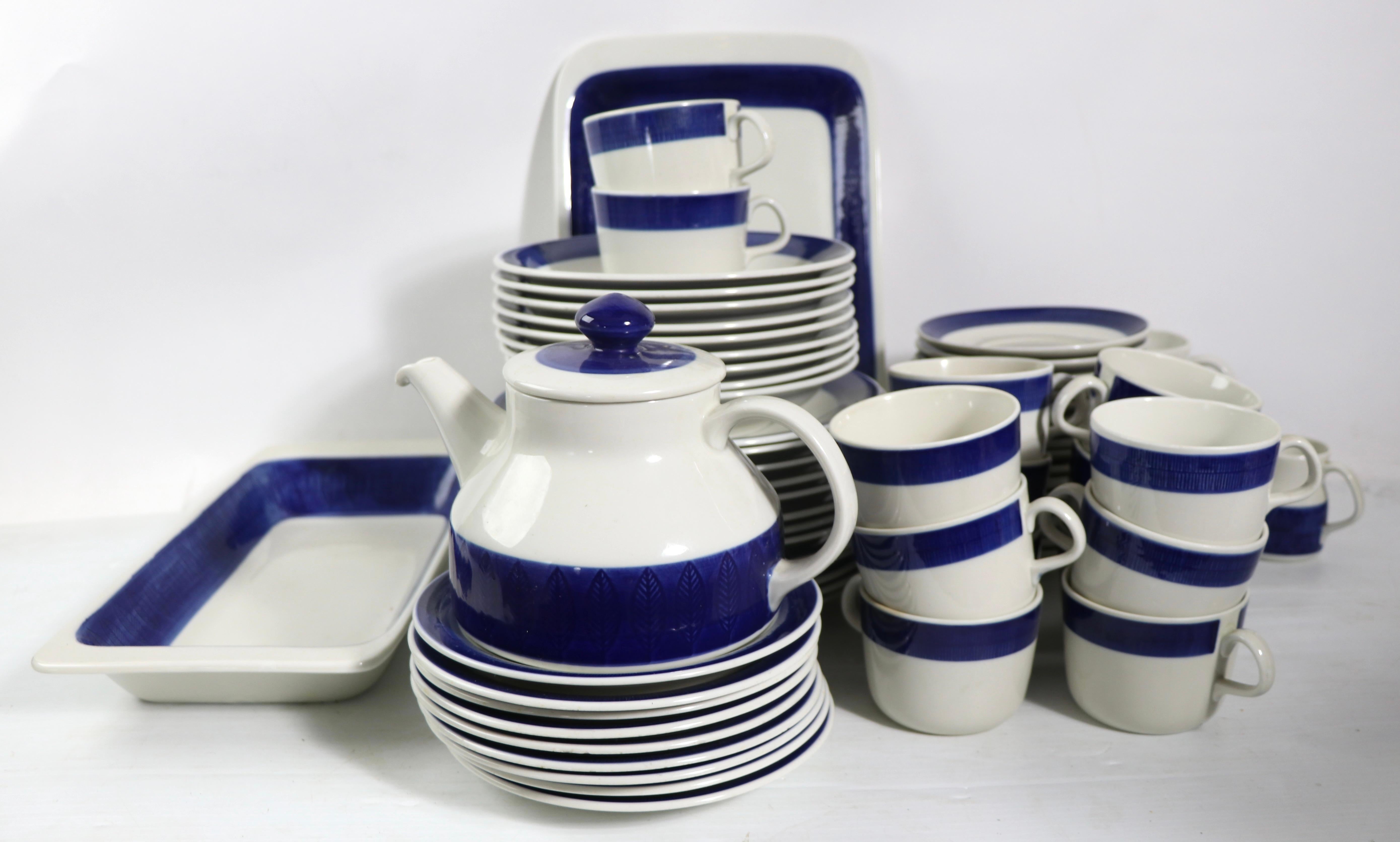 Rare opportunity to purchase a large set of Koka pattern dinnerware designed by Hertha Bengtsson. The set is free of chips, or cracks, some plates show knife marks to the surface, normal and consistent with age. 
Set to include:
 14 Cups
 18