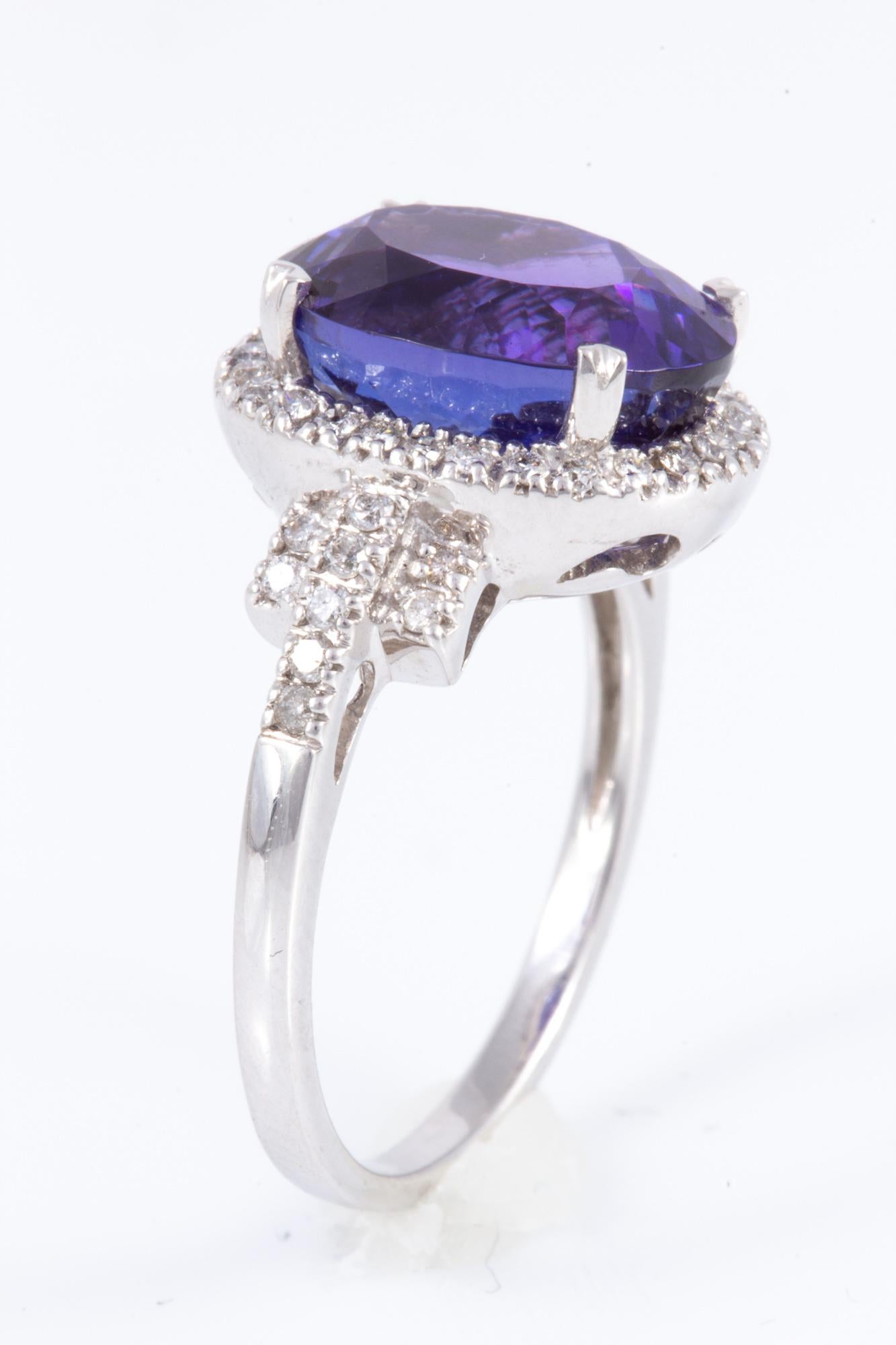 Exceptionally well cut and saturated 6.70 carat oval Tanzanite beautifully balanced with .50 Carats of well cut diamonds. Set in 14 karat gold and made in America! The perfect combination of cut and color.  

Presented by the noted jewelry firm of