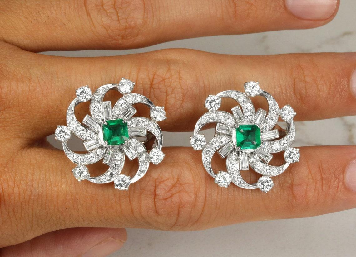Displayed is a sensational pair of emerald and diamond disc earrings. Asscher cut, green emeralds are prong set in luxurious Platinum. These natural gems have excellent luster and outstanding clarity, each matching perfectly with one another.