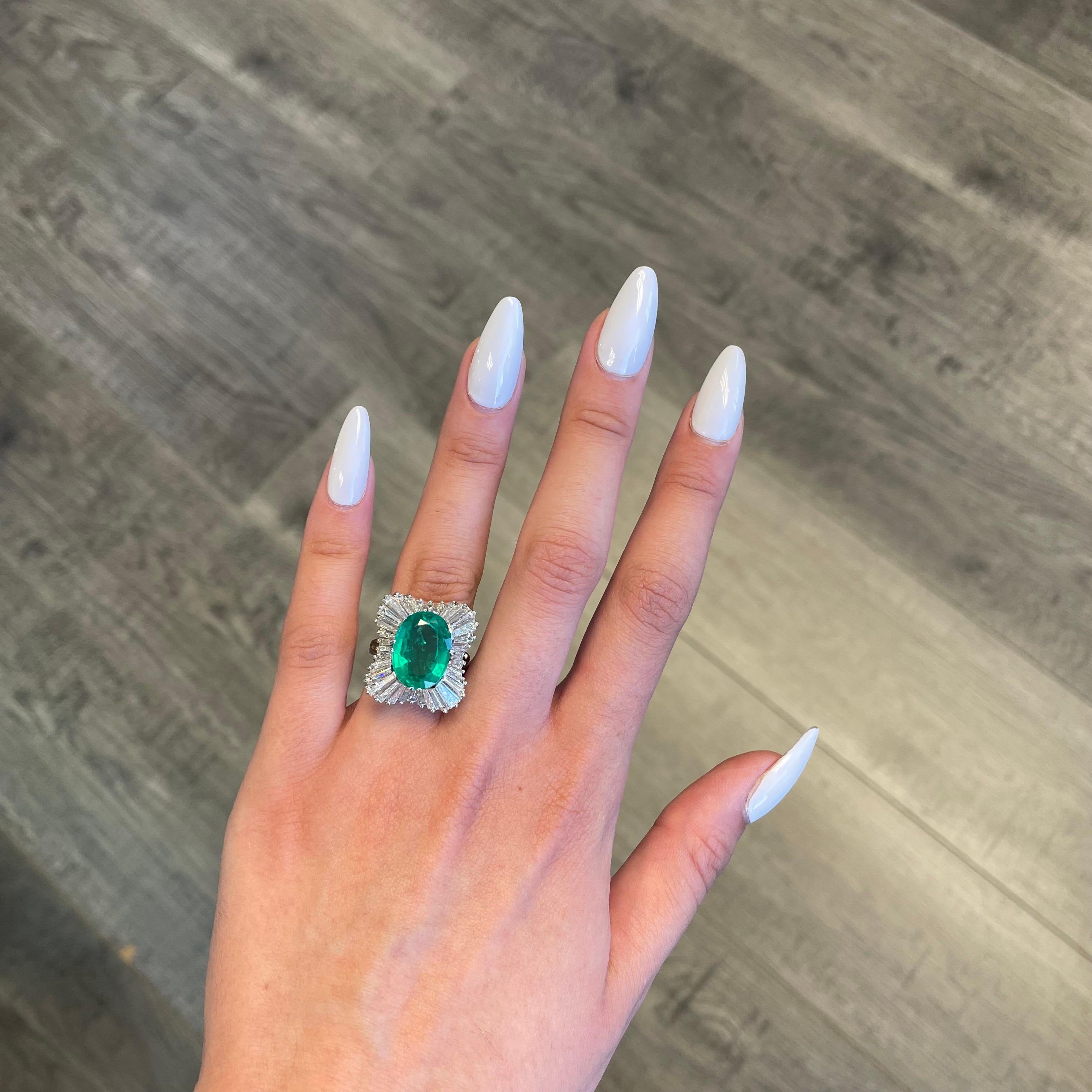 Lovely vintage inspired emerald with diamond ballerina setting ring.
6.72 carat oval emerald apx F2 complimented with 34 baguette diamonds, approximately 1.75ct. Approximately G/H color and VS clarity. 8.47ct total gemstone weight, in 18k white