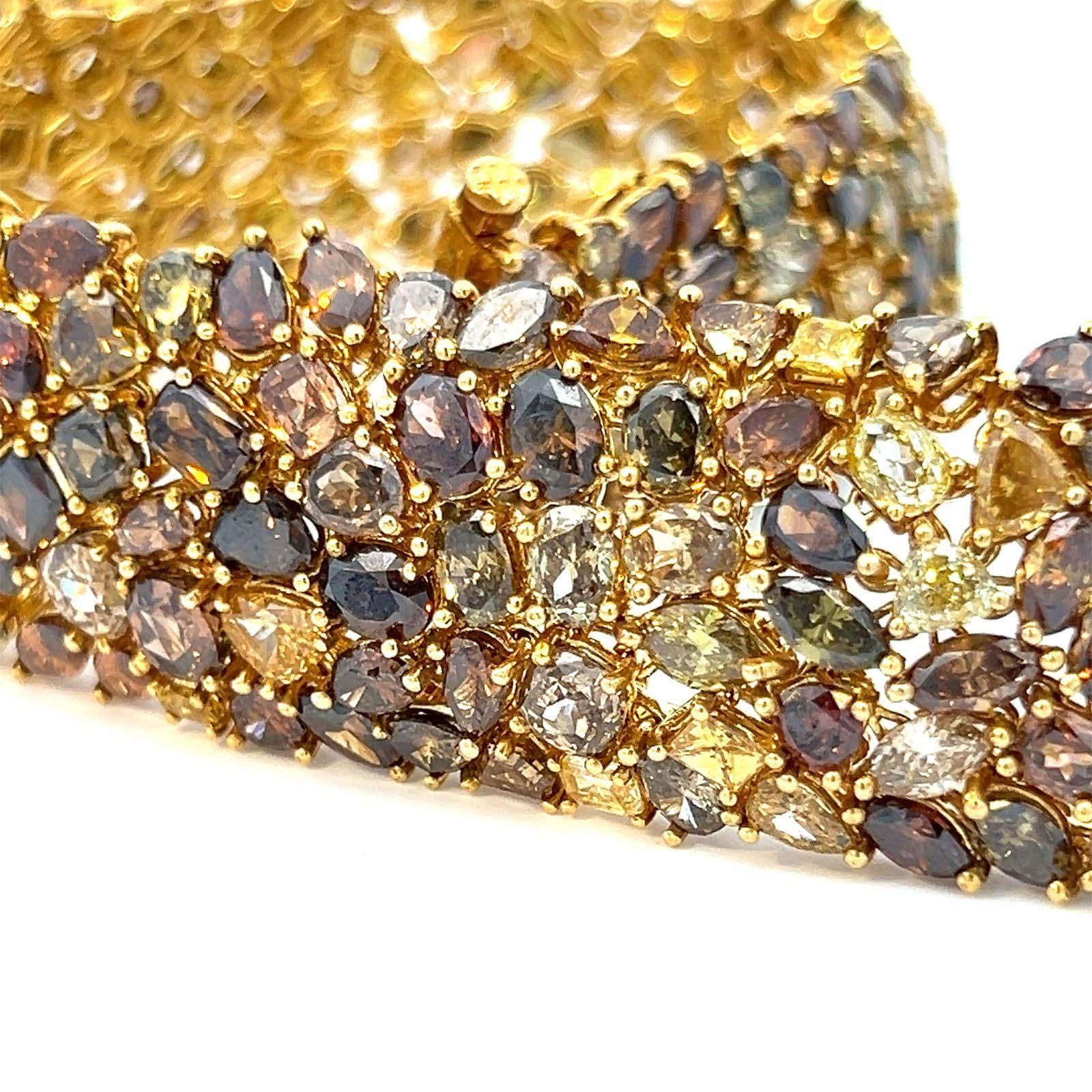 18 karat yellow gold bracelet with an astounding 67.25 carats of multi-fancy color diamonds. Crafted with meticulous attention to detail, this one-of-a-kind piece boasts a captivating array of 235 yellow, orange, brown, and green diamonds in various