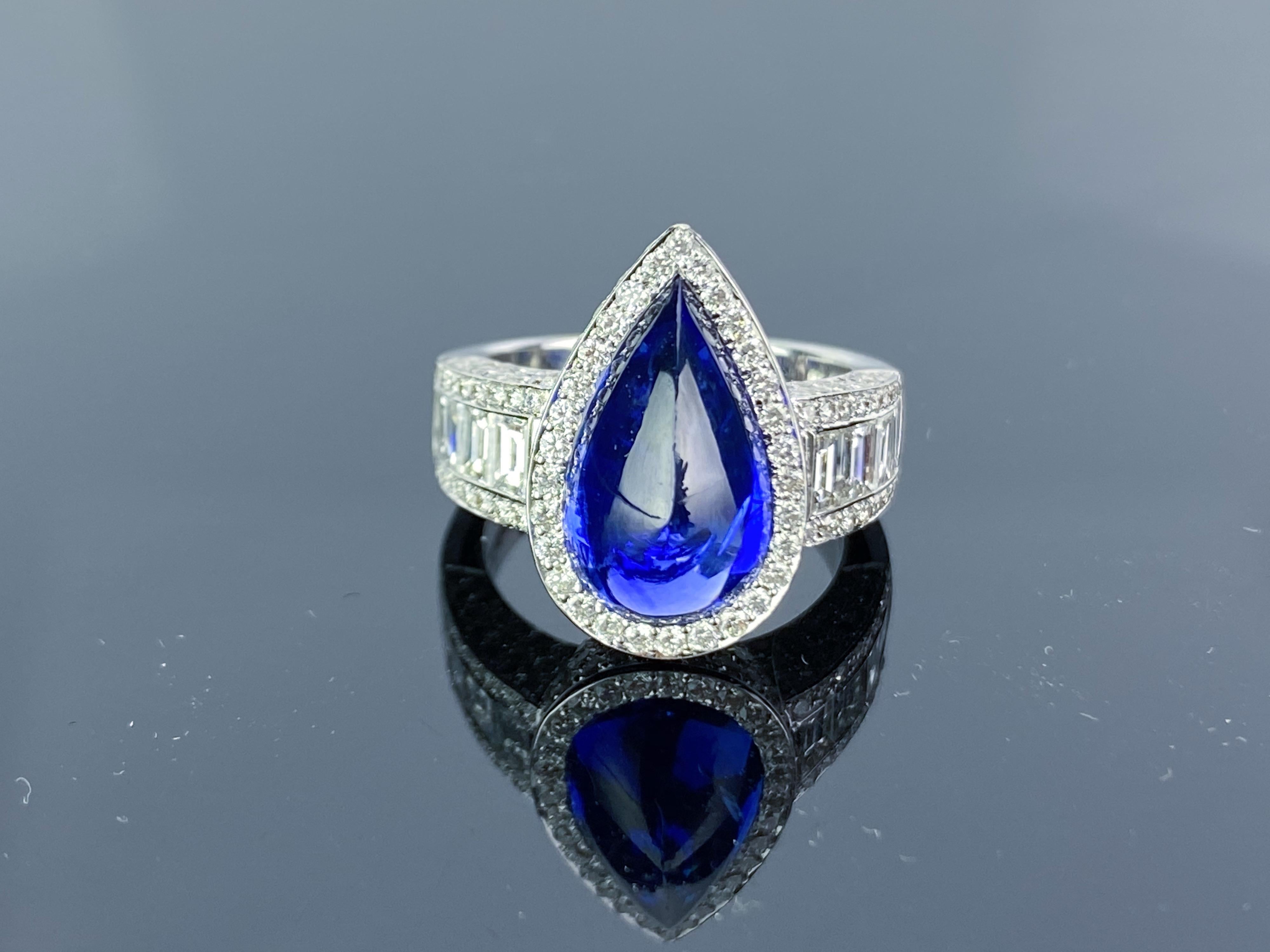 A stunning pear shape cabochon 6.74 carat Ceylon Sapphire ring, with top quality diamonds on the bands, all set in 18K white gold. The Sapphire is eye-clean, with no inclusions and has a great lustre to it. Currently a ring size US 6, but we can