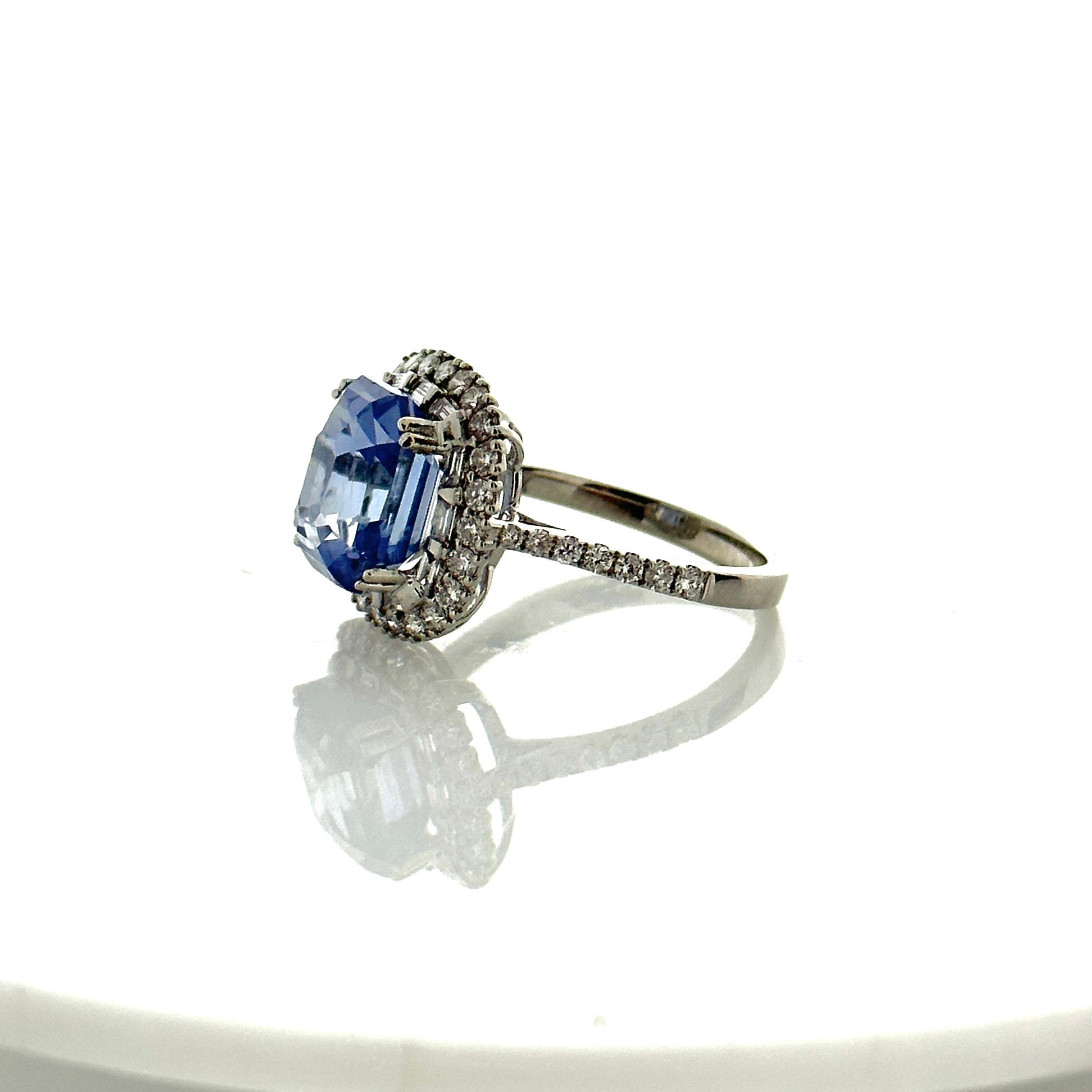 This is a 6.74 carats royal blue sapphire that is surrounded by a stunning halo of round brilliant diamonds. The sapphire is from Sri Lanka. The color is royal blue; its luster, clarity, and transparency are exceptional. The 0.89 carat total weight