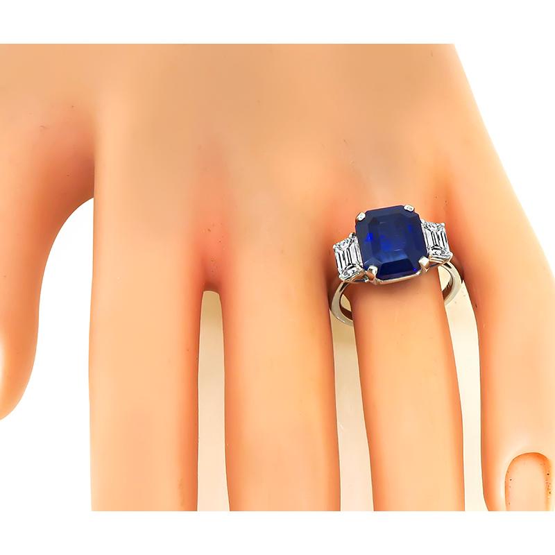 This is a stunning platinum engagement ring. The ring is centered with a lovely emerald cut Ceylon sapphire that weighs approximately 6.76ct. The center stone is accentuated by sparkling GIA certified emerald cut diamonds that weigh approximately