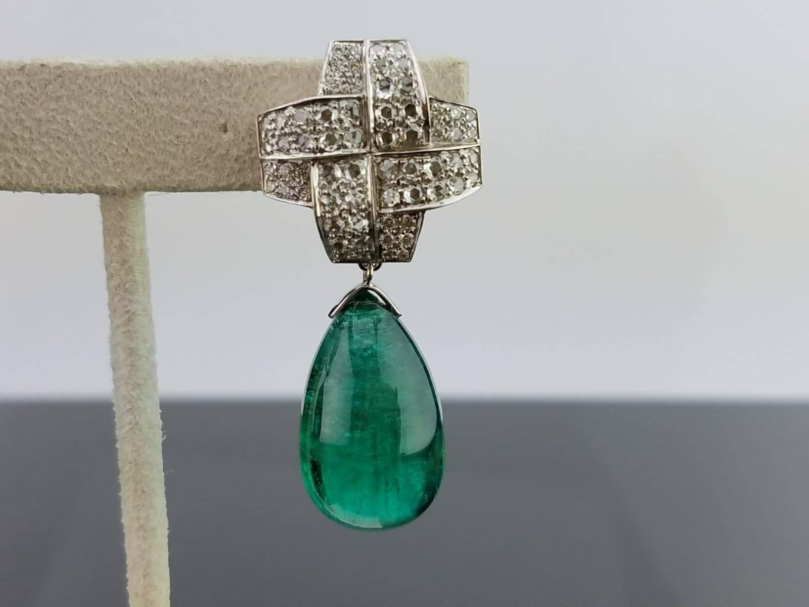 A pair of very unique drops earring with omega backing, using Emerald of great colour and clarity and Diamond set in 18K white gold.   

Stone Details: 
Stone: Zambian Emerald 
Carat Weight: 2pcs / 67.95 Carats  (around 33.5 carat each)

Diamond