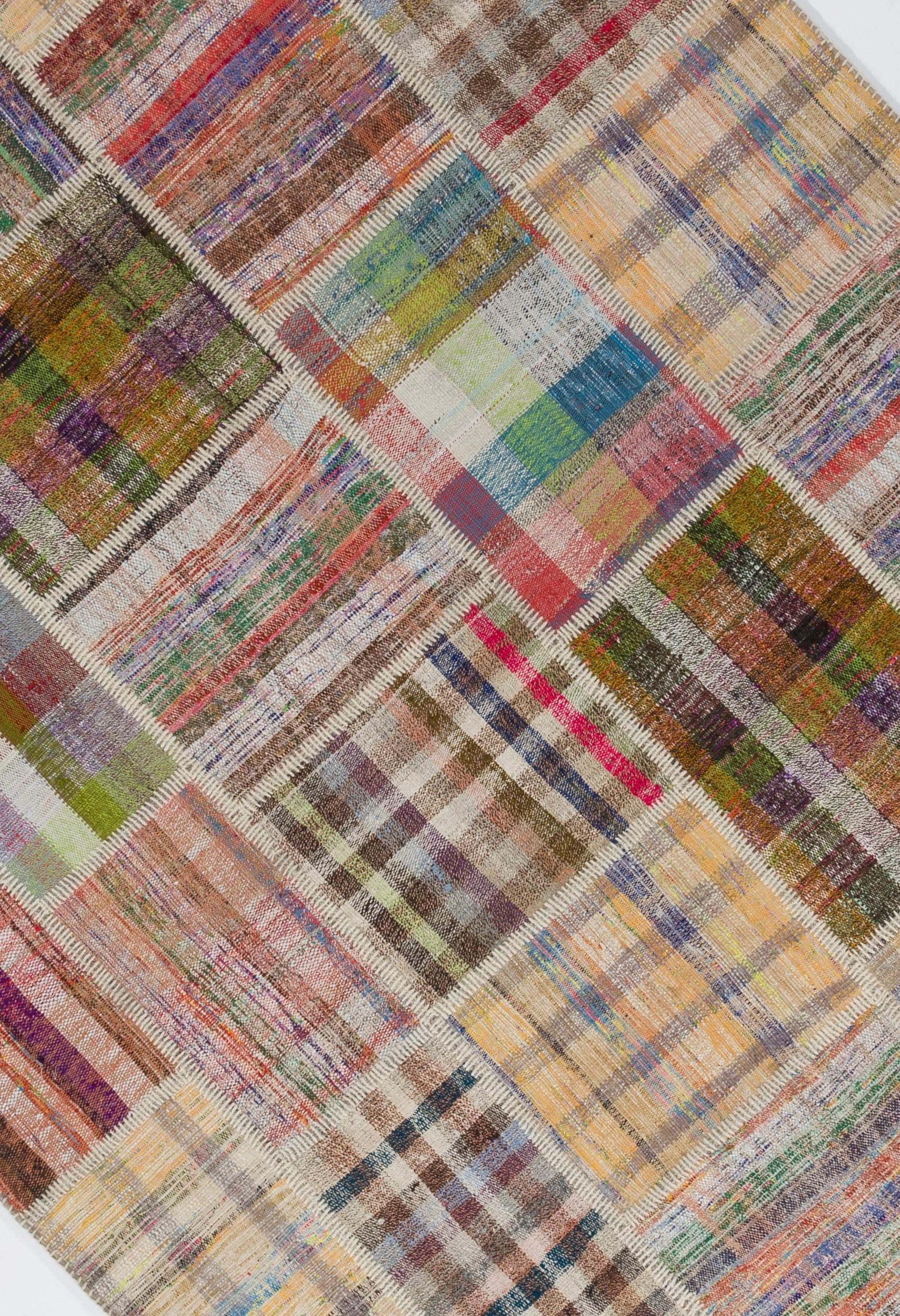 A fun floor covering made of pieces of assorted vintage handmade Anatolian kilims (flat-weaves) in cheerful rainbow colors featuring various checkered patterns.

The Kilim is made of wool, cotton and goat hair. The patches are individually hand
