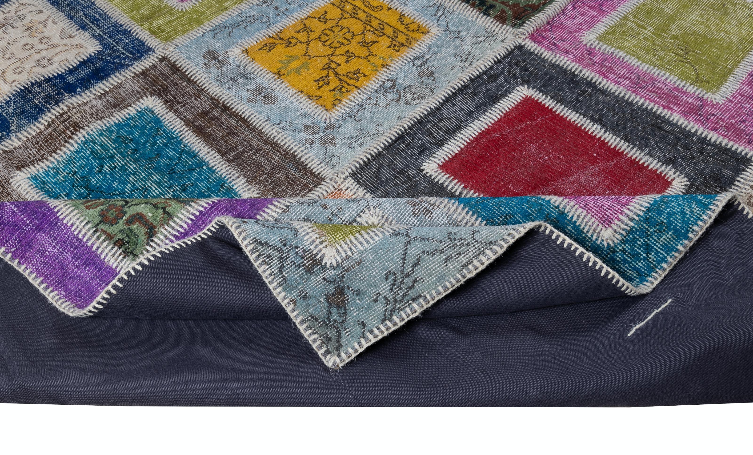 Assorted pieces of vintage hand-knotted Turkish carpets were washed, sheared, re-dyed in various colors, cut into geometric shapes then stitched together by hand to create this beautiful one of a kind patchwork rug. 
A durable dark color cotton
