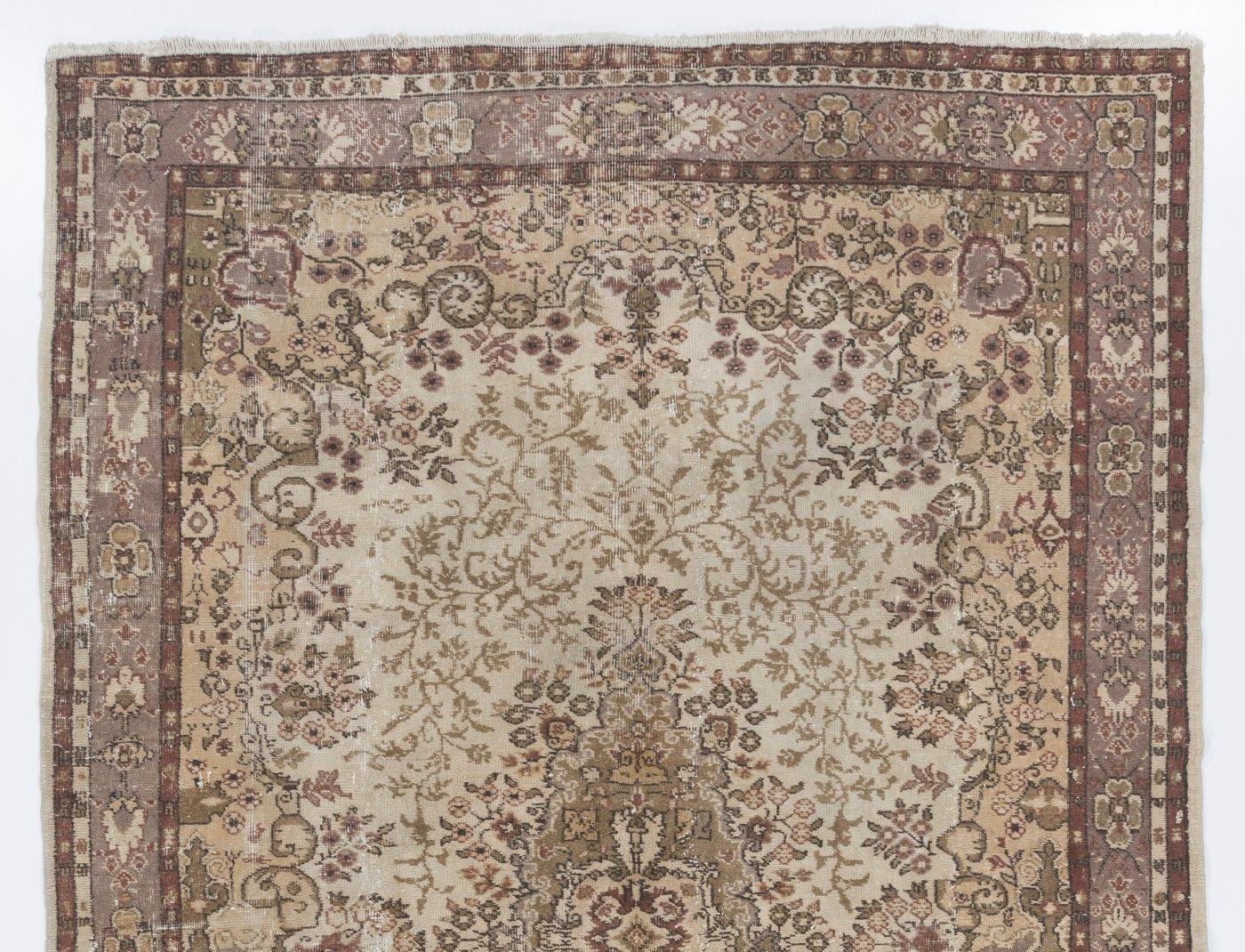 A finely hand-knotted vintage Turkish carpet from 1950s featuring an elegant medallion design in beige, brown and green. The rug has even low wool pile on cotton foundation. It is heavy and lays flat on the floor, in very good condition with no