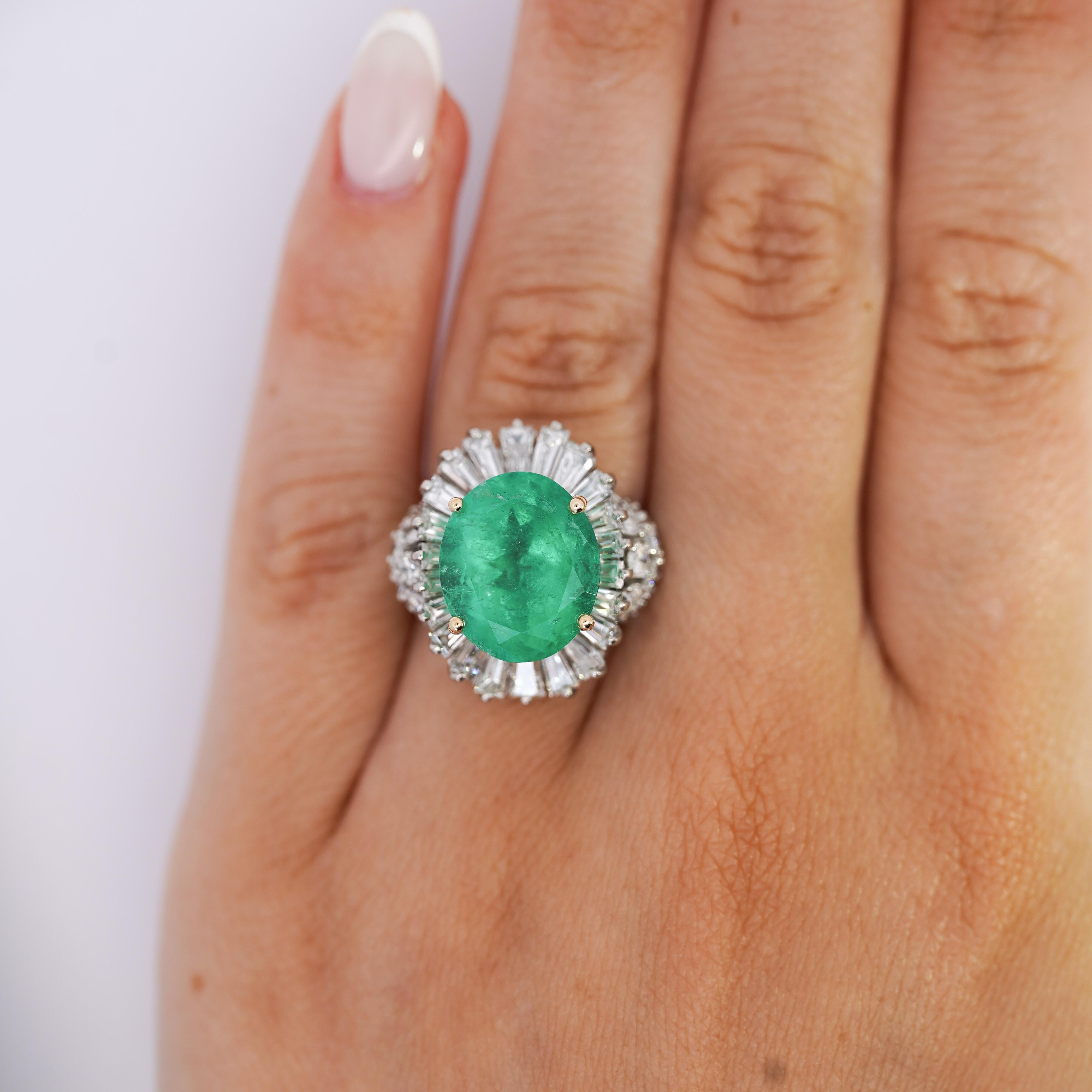 This stunning Platinum ring showcases an exquisite 6.82 carat oval-cut Colombian emerald at its center, surrounded by a halo of diamonds. The deep, rich yellowish green hue of the emerald is complemented by 20 round diamonds on the band and 22