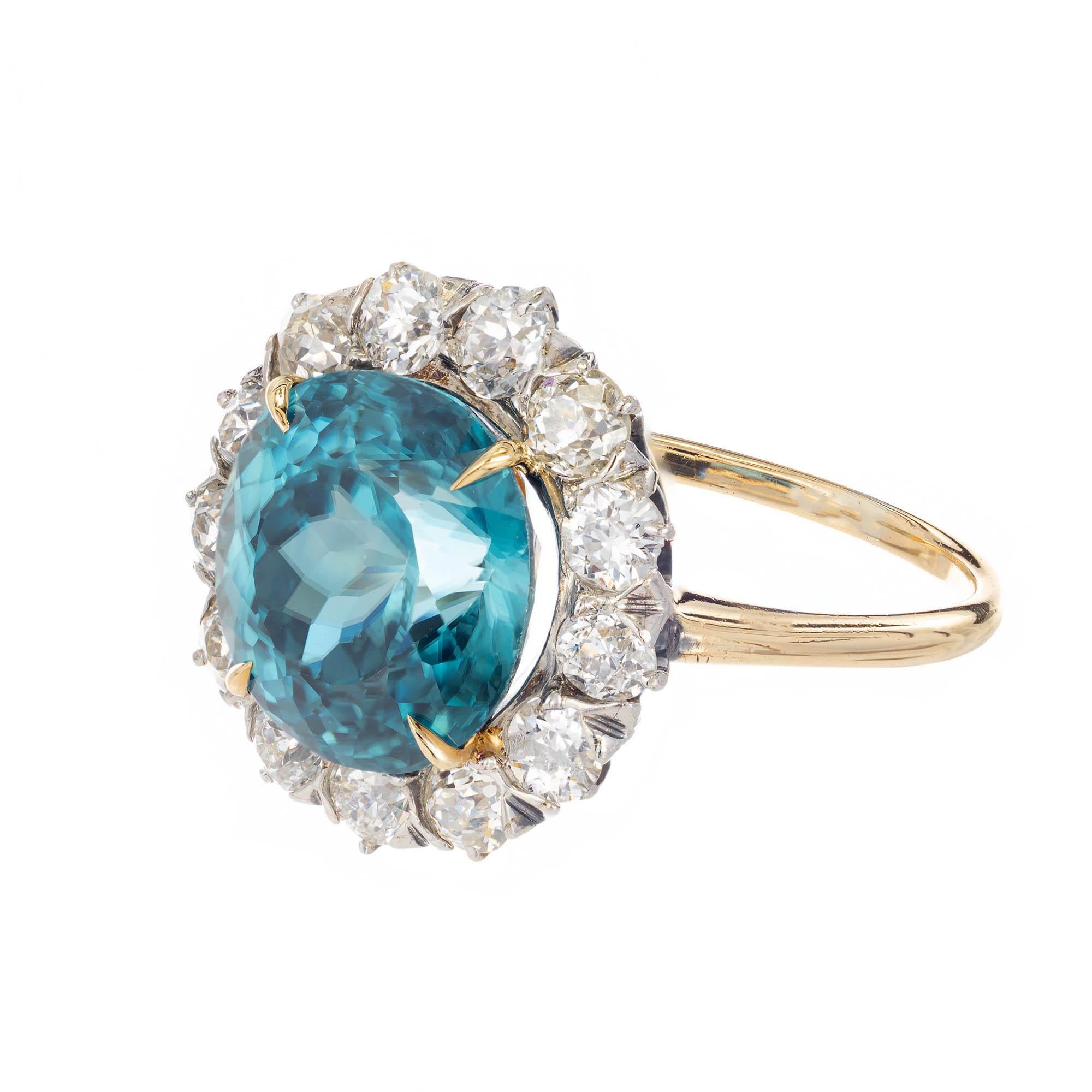 Blue zircon and diamond halo engagement cocktail ring. Round deep blue zircon set with yellow gold prongs with a halo of Old European cut diamonds set in platinum attached to a 14k yellow gold setting.

1 round blue zircon Approximate 6.80 carats
13