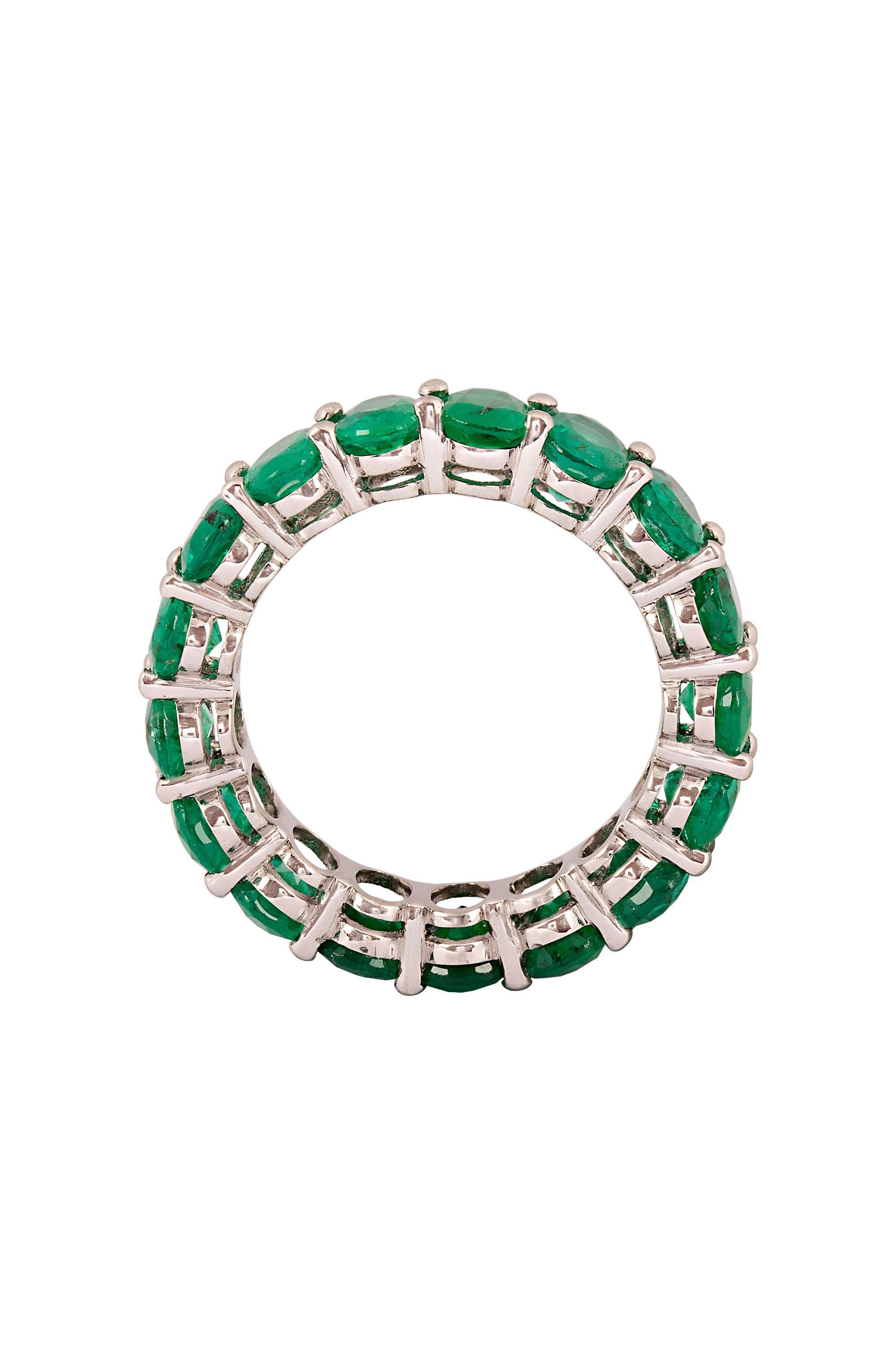 A gorgeous eternity band composed of seventeen vivid green oval emeralds set in a discreet platinum mounting. Unique, polished and gorgeous. Created and crafted in Beverly Hills by Gems Are Forever, Inc. With a total emerald weight of approximately
