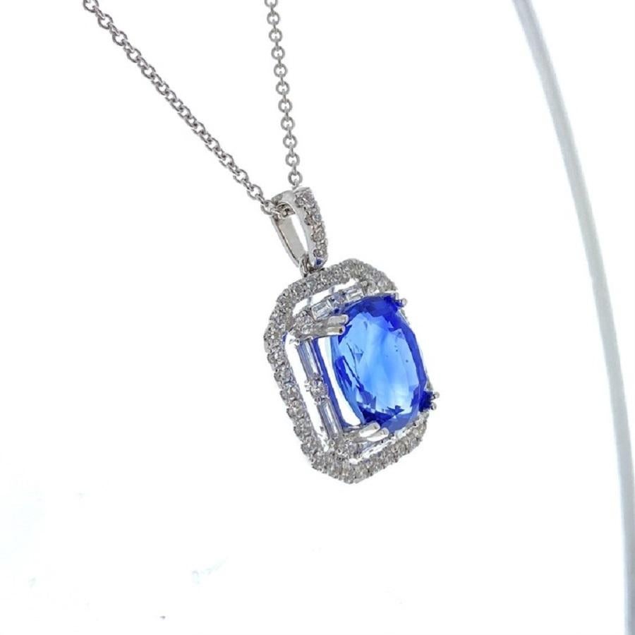 This pendant is an extraordinary blend of elegance and luxury. Crafted in 18 karat white gold, it showcases a magnificent 6.81 carat cushion-shaped blue sapphire as its centerpiece. The deep blue hue of the sapphire is enchanting, radiating a sense