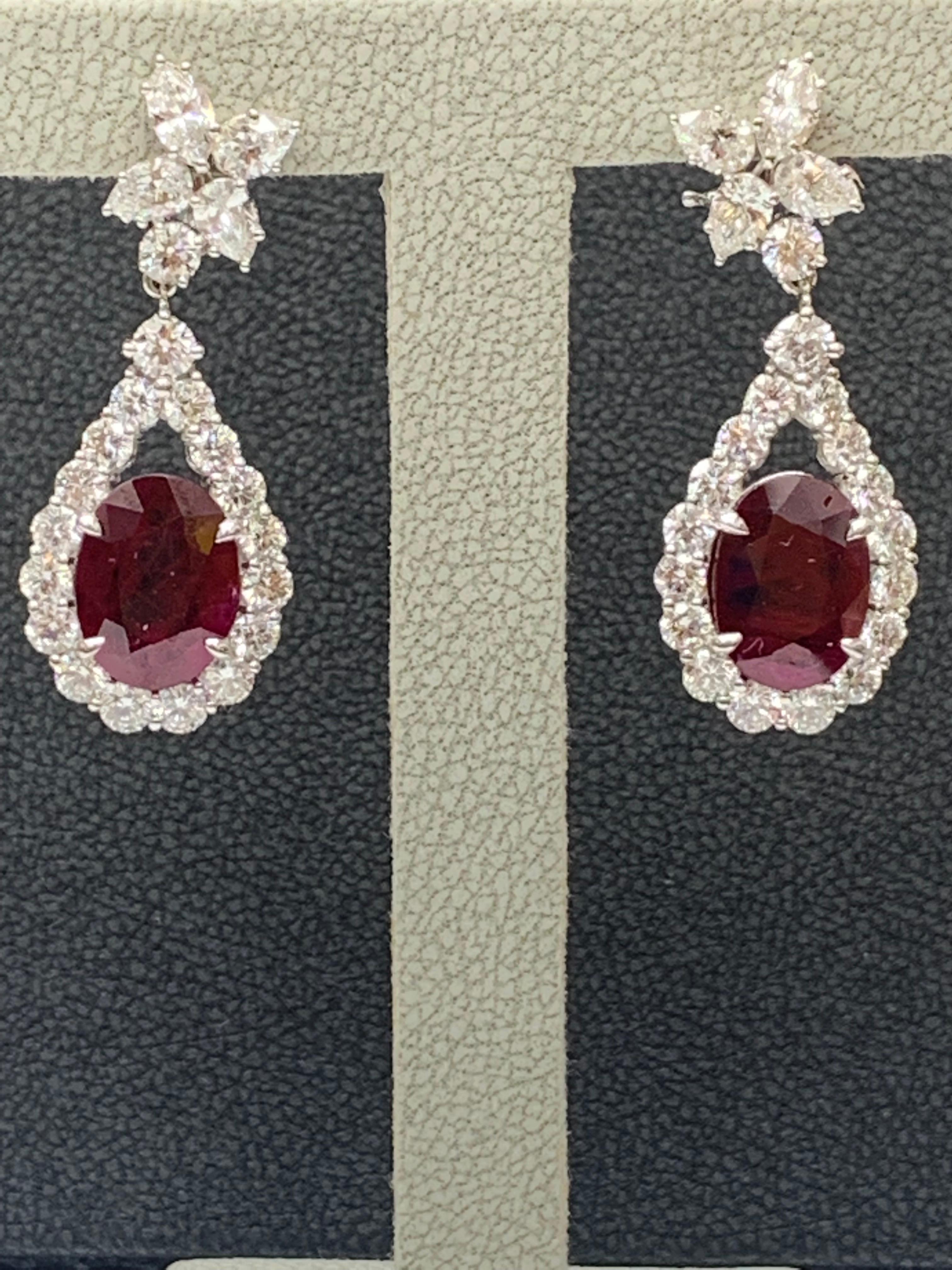 A beautiful and chic pair of drop earrings showcasing a cluster of brilliant mixed-cut diamonds, and an oval brilliant-cut Rubies set in an intricate and stylish design. 8 Mixed cut Diamonds weigh 1.62 carats in total. 2 rubies weigh 6.81 carats in