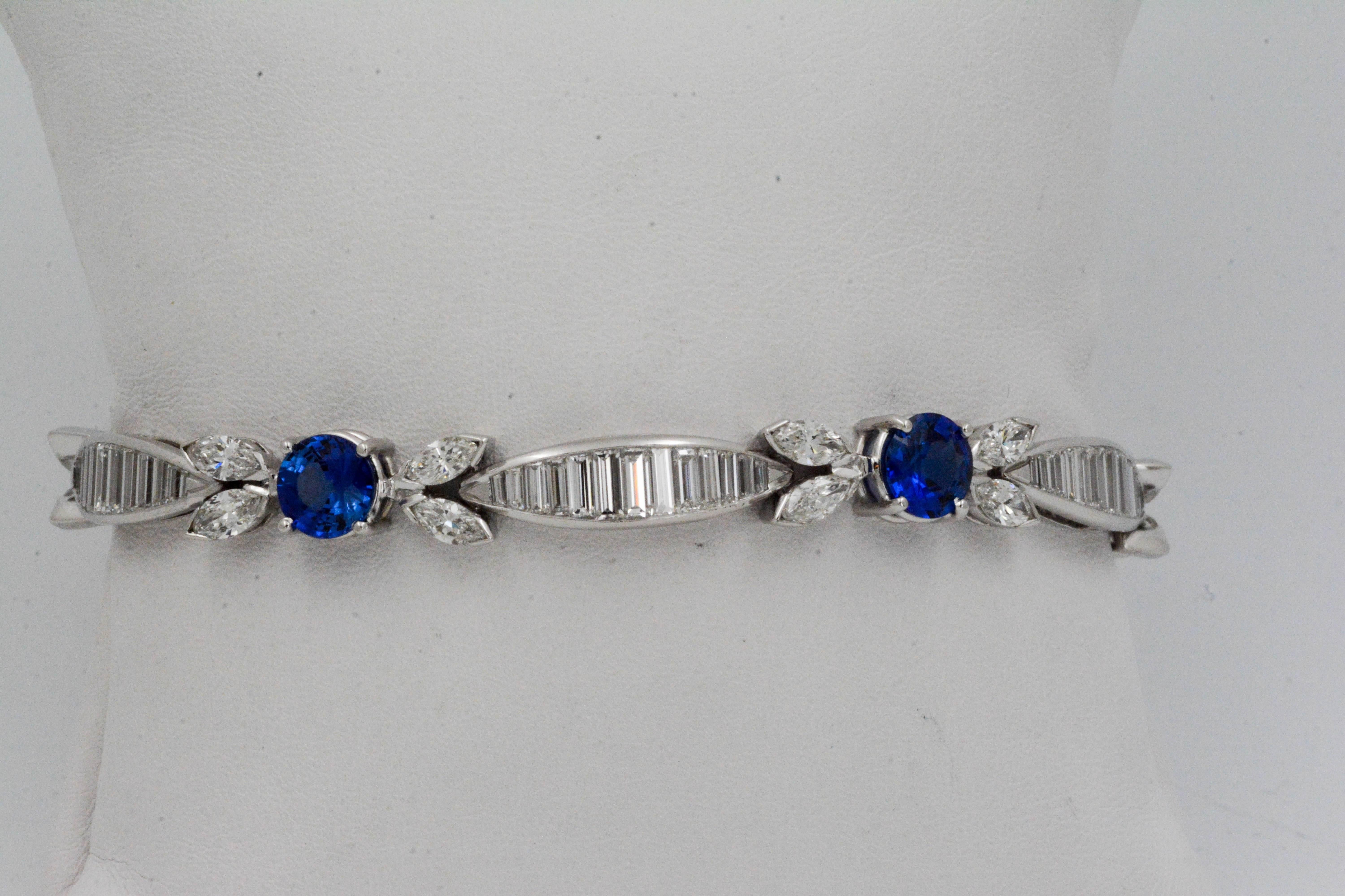 Brilliant, sophisticated, sparkly--and oh so irresistible, this Sapphire and Diamond Platinum bracelet has distinctive charm. 5 round faceted blue sapphires (6.85 carat total weight) are surrounded by 20 ravishing marquise diamonds, set in two on