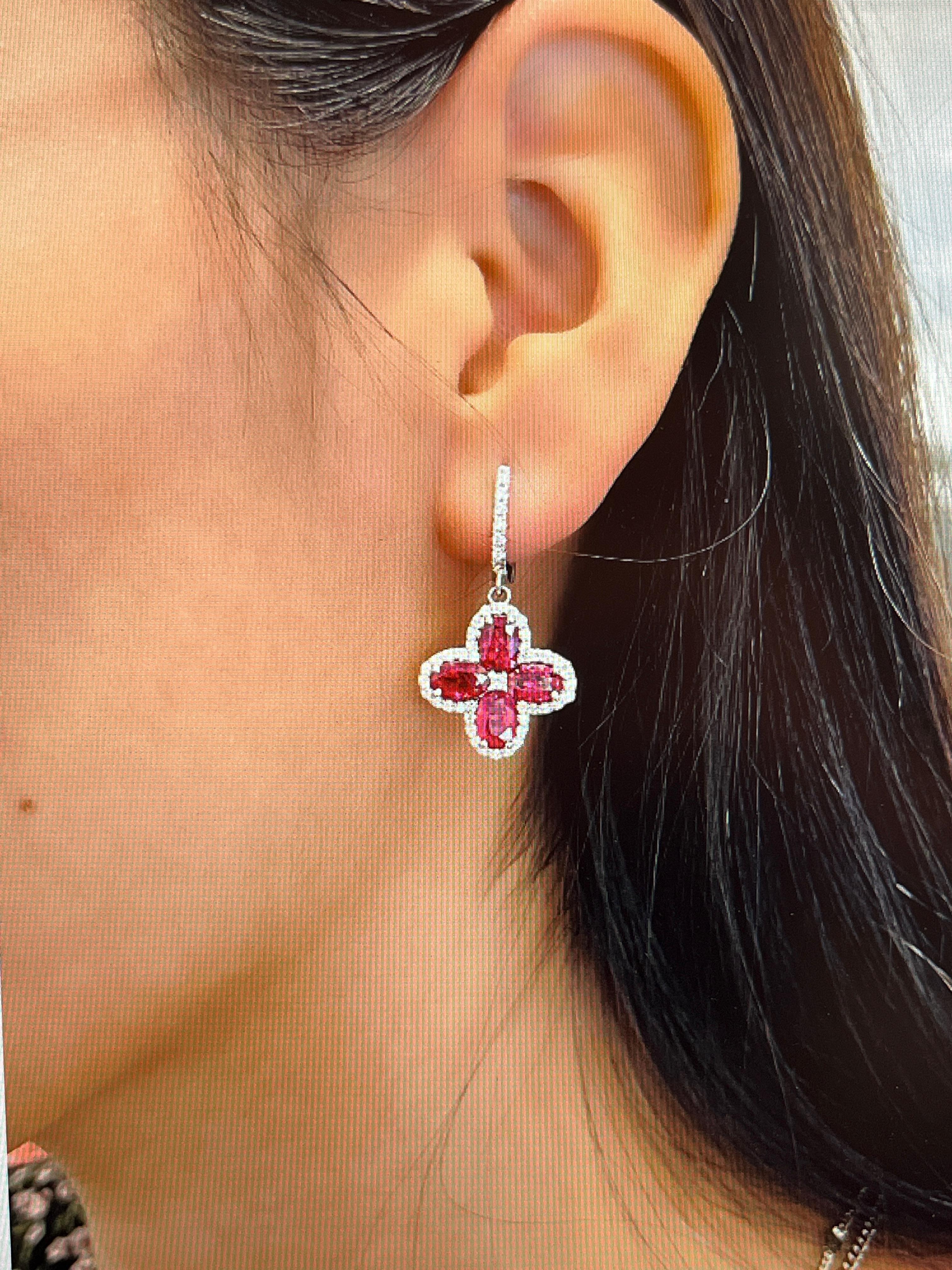 These stunning 6.87 ctw natural Burma ruby and diamond earrings feature 8 oval shape rubies weighing 6.01 ct surrounded by 94 diamonds weighing 0.86 ct set in 18k white gold. The diamonds are E/F in color, and VS1/VS2 in clarity. A great addition to