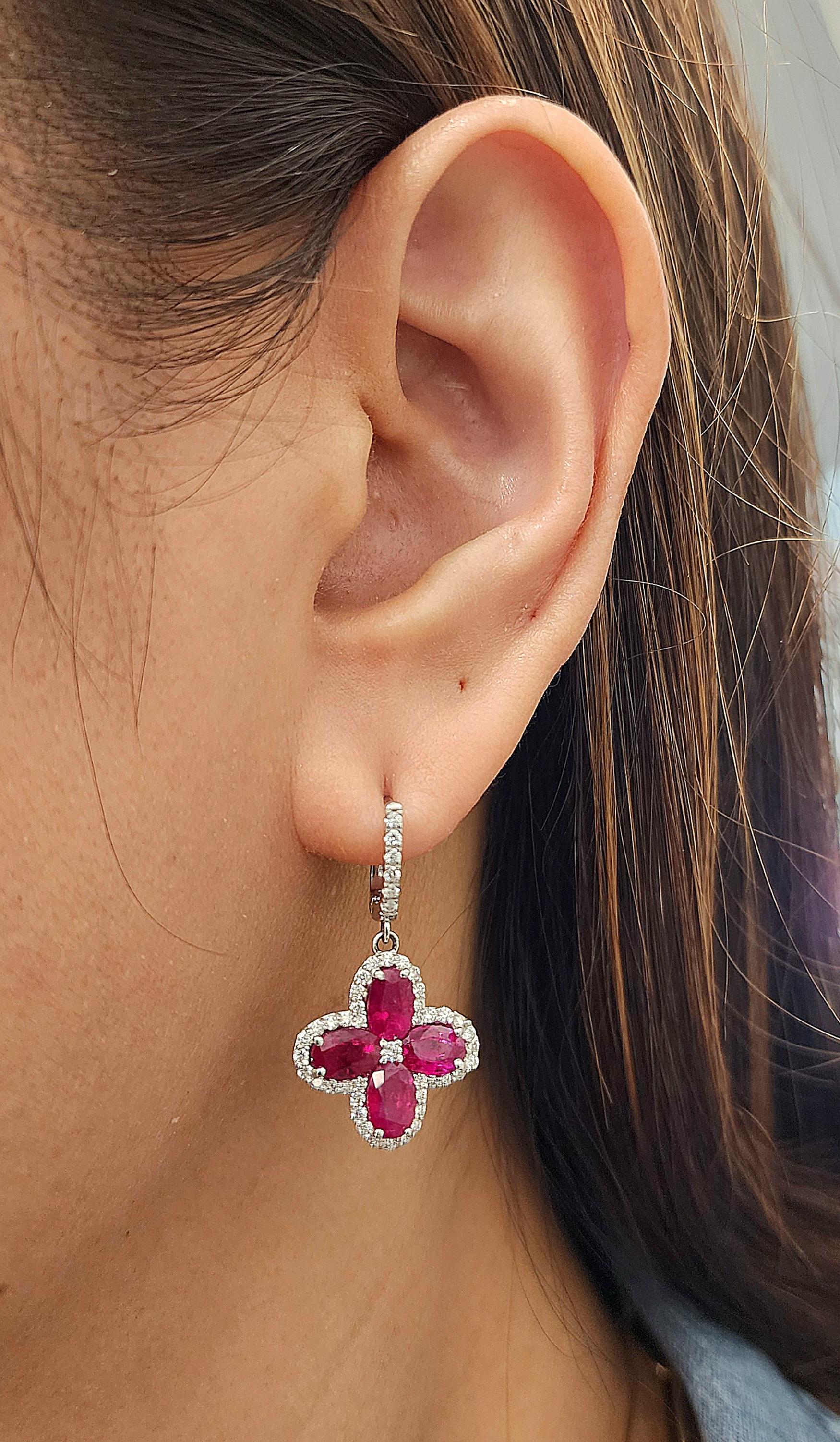 These stunning 6.87 ctw natural Burma ruby and diamond earrings feature 8 oval shape rubies weighing 6.01 ct surrounded by 94 diamonds weighing 0.86 ct set in 18k white gold. The diamonds are E/F in color, and VS1/VS2 in clarity. A great addition to