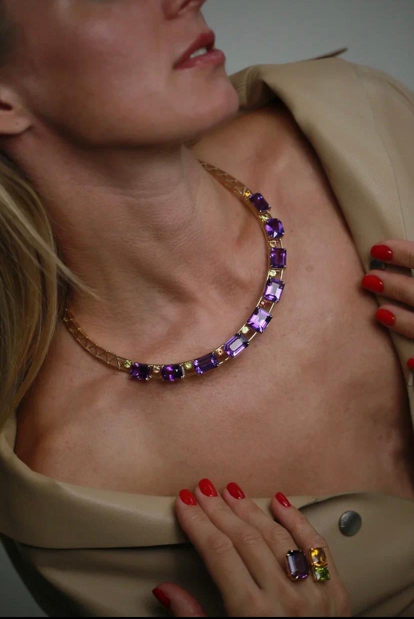 This magnificent feminine 18 K yellow gold necklace features 65.43 Ct amethyst 1.65 Ct period and 1.65 Ct orange sapphire. 9 amethysts are presented in different shapes such as rectangular cut, can cut, radiant cut and emerald cut.

This necklace is