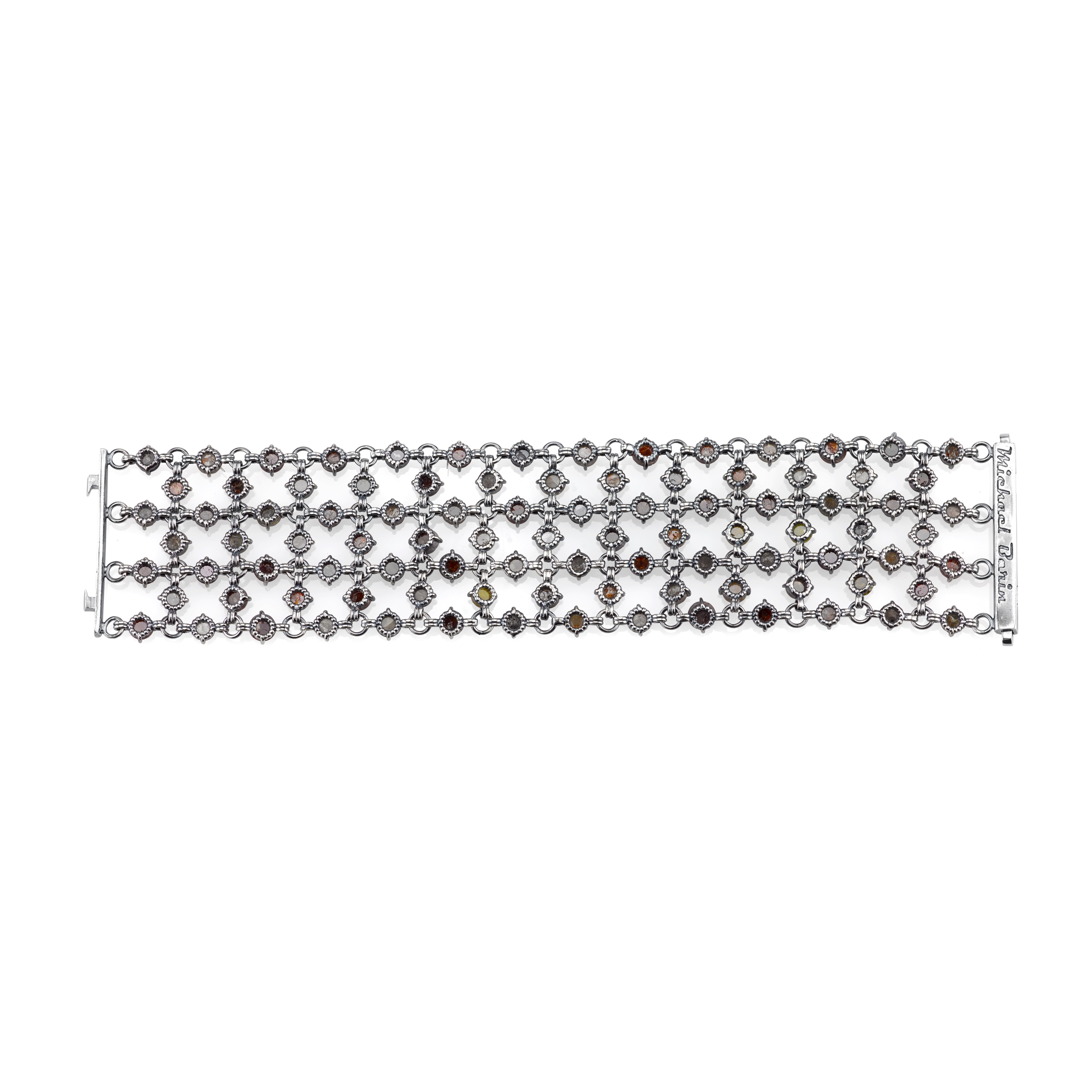  This stunning bracelet showcases 68 carats of natural and earthy rustic diamonds, set against the muted tones of Organic Silver. With a hand-engraved design on the clasp, this piece showcases a perfect balance between modern and traditional