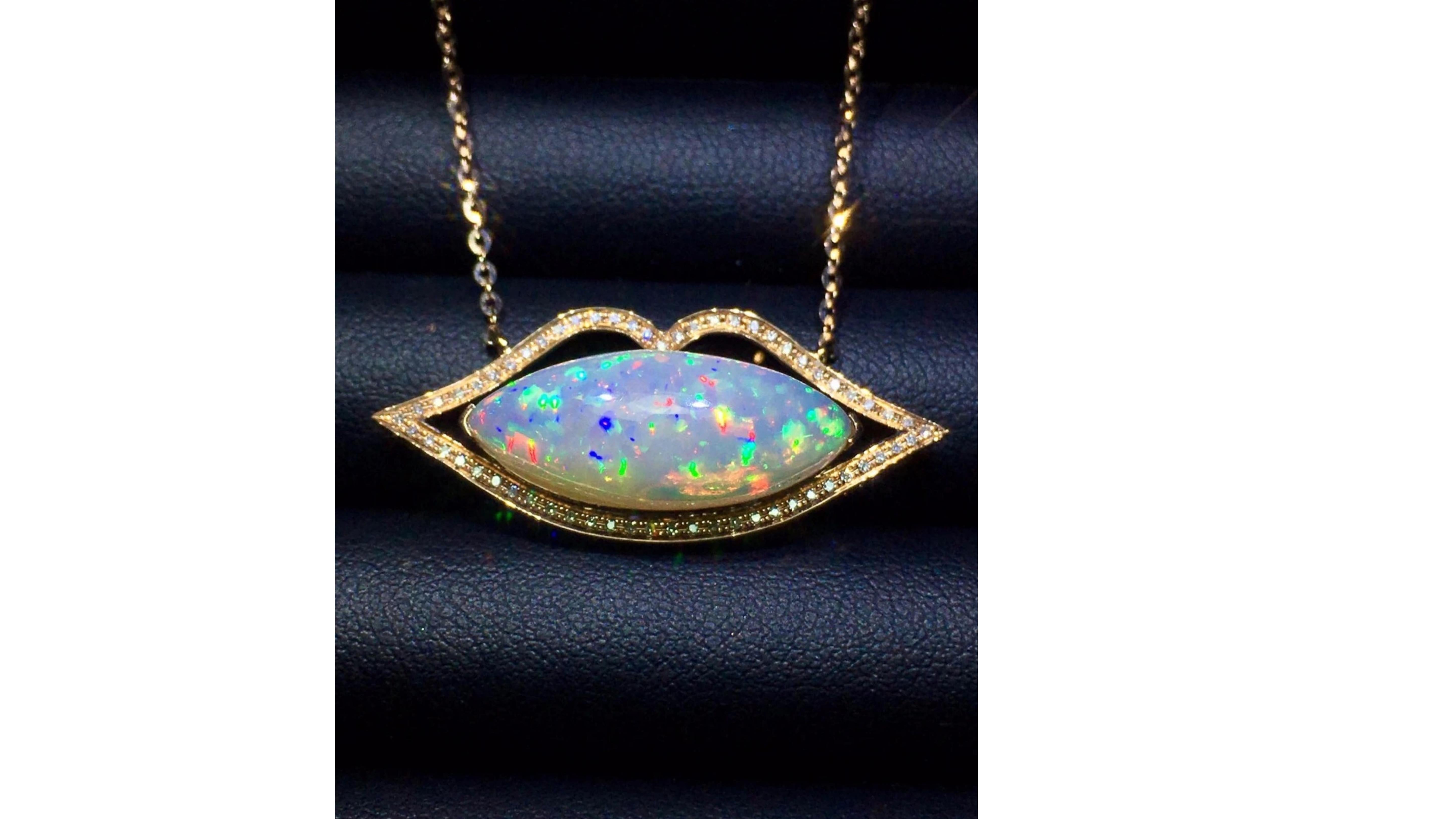 
Ethiopian Opal Necklace with 67 Diamonds  . This 6.9 Cart Opal Shows off bright colors Blue Yellow Green White Orange Purple and the Wello province in Ethiopia is known for these colors  that make them stand out .  This Lip shape pendant  does make