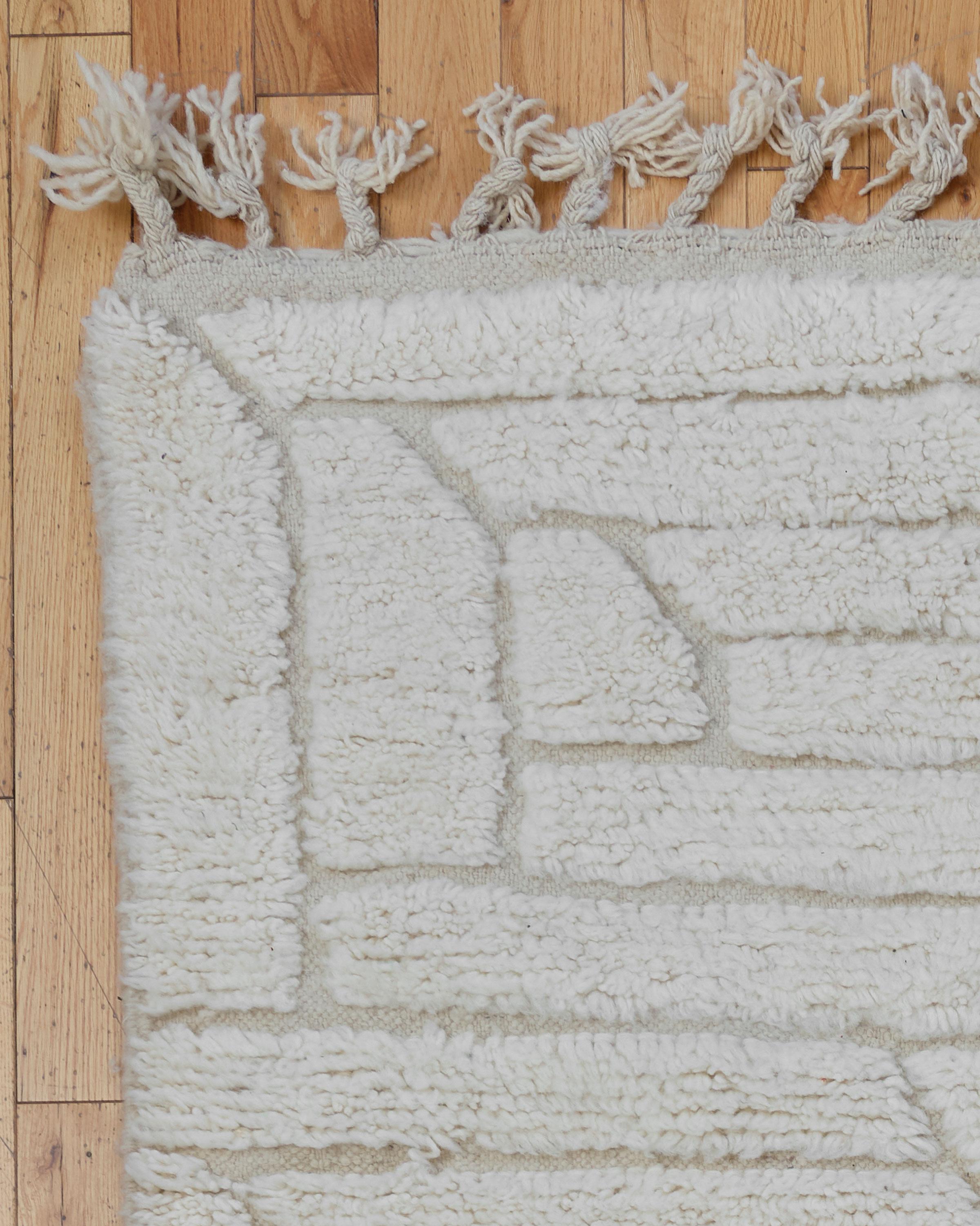 The Heron rug is a stunning Beni Ouarain piece, handwoven by skilled Berber artisans in the Atlas Mountains of Morocco. Featuring a soft cream background, this rug showcases minimalist geometric designs that reflect the traditional artistry of Beni