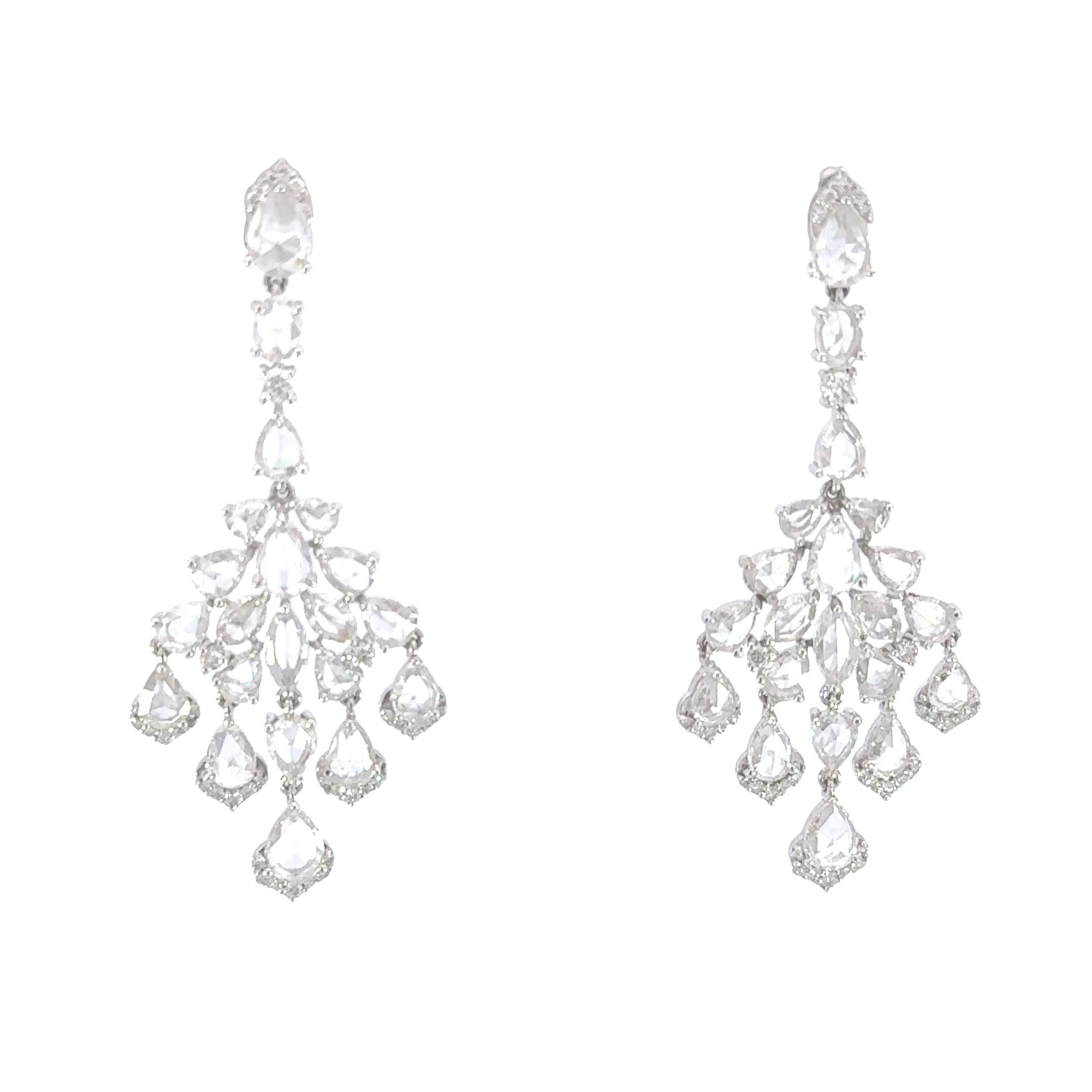 These stunning earrings exude an aura of timeless elegance, showcasing a captivating combination of rose cut diamonds cascading down with a brilliant round diamond contour, all embraced in the finest 18K white gold setting. The distinctive design